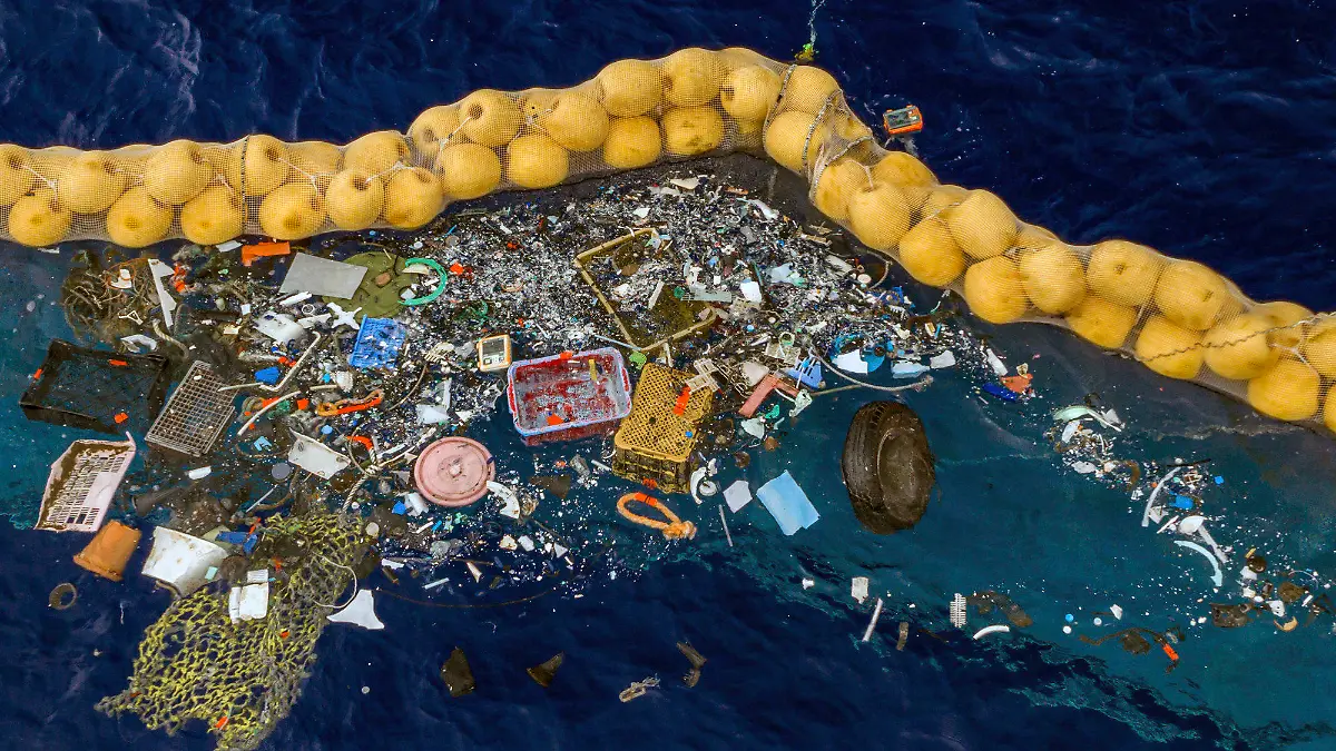 30.09.2019, ---: Auf diesem undatierten und von The Ocean Cleanup zur Verfügung gestellten Bild schwimmen Plastikstücke vor einer Dichtung im Meer. Boyan Slat aus den Niederlanden, der dies erfunden haben soll, behauptet, das System zum Auffangen von Kunststoffresten, die im Pazifik zwischen Kalifornien und Hawaii schwimmen, funktioniert. Slat, ein Studienabbrecer, gründete die gemeinnützige The Ocean Cleanup. Foto: Uncredited/The Ocean Cleanup/dpa +++ dpa-Bildfunk +++