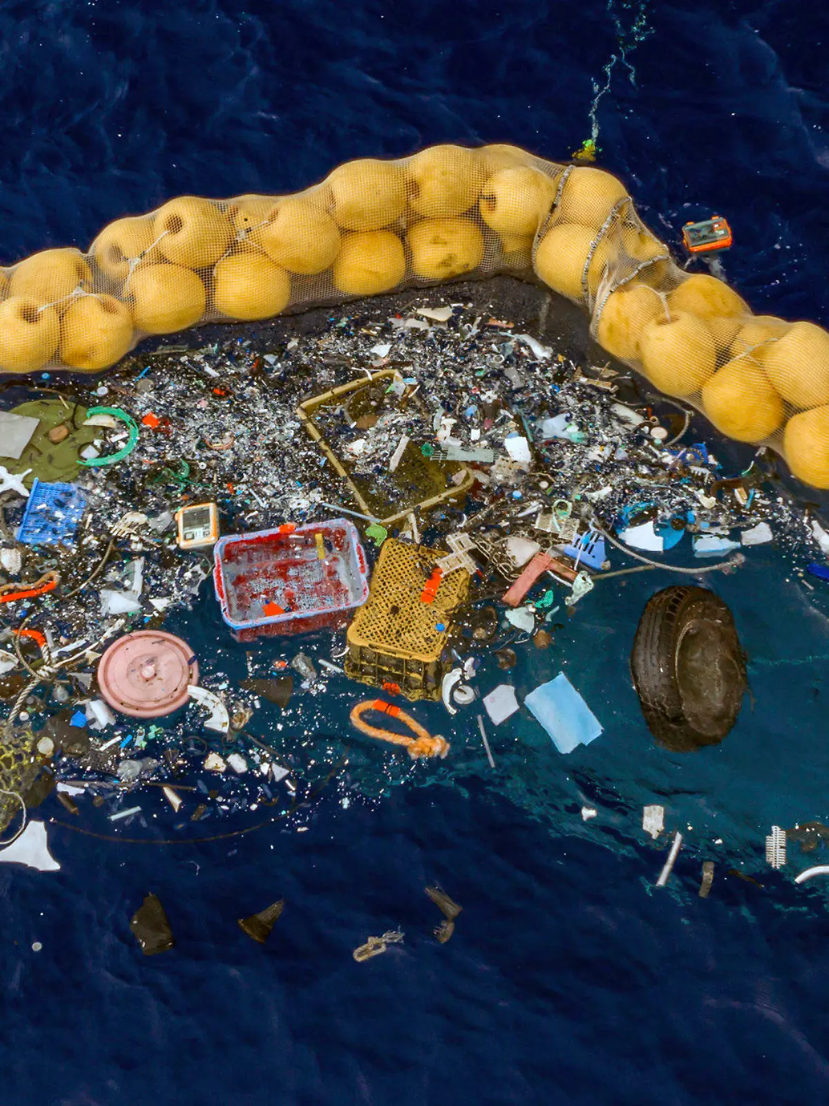 30.09.2019, ---: Auf diesem undatierten und von The Ocean Cleanup zur Verfügung gestellten Bild schwimmen Plastikstücke vor einer Dichtung im Meer. Boyan Slat aus den Niederlanden, der dies erfunden haben soll, behauptet, das System zum Auffangen von Kunststoffresten, die im Pazifik zwischen Kalifornien und Hawaii schwimmen, funktioniert. Slat, ein Studienabbrecer, gründete die gemeinnützige The Ocean Cleanup. Foto: Uncredited/The Ocean Cleanup/dpa +++ dpa-Bildfunk +++