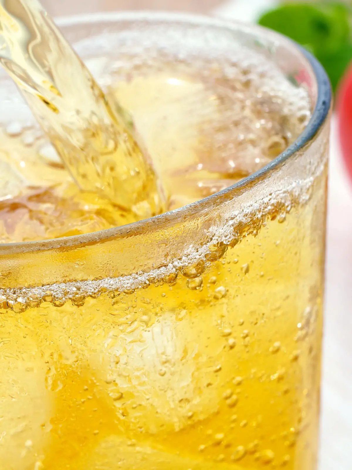 Apfelschorle wird in ein Glas geschüttet.