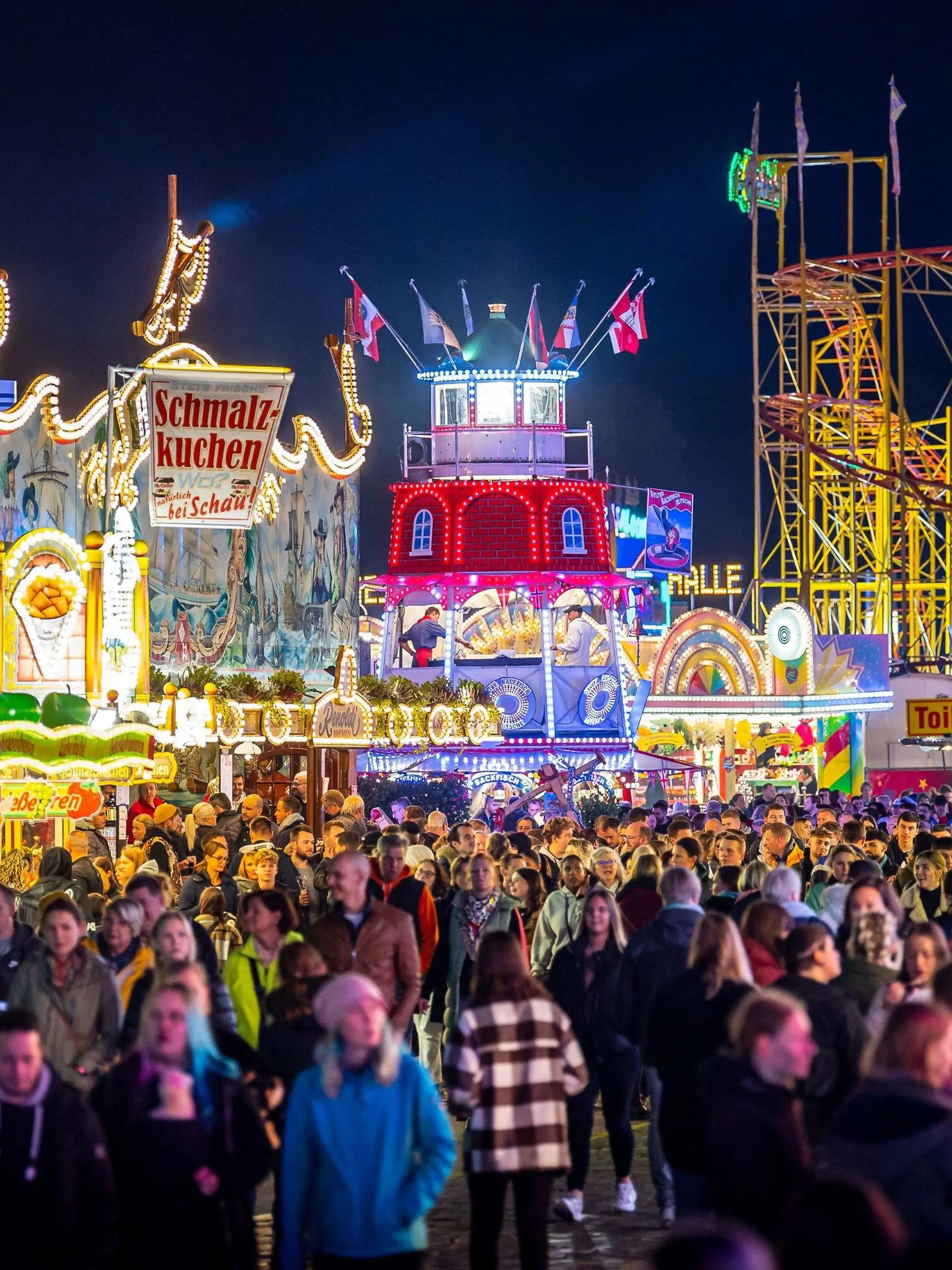 ARCHIV - 14.10.2022, Bremen: Die Fahrgeschäfte auf dem Freimarkt auf dem Bürgerweide leuchten mit bunten Lichtern und Reklameschriftzügen. Der Bremer Freimarkt ist eines der ältesten Volksfeste Deutschlands und das größte im Norden. (zu dpa "Schausteller: Volksfeste müssen in öffentlicher Hand bleiben") Foto: Sina Schuldt/dpa +++ dpa-Bildfunk +++
