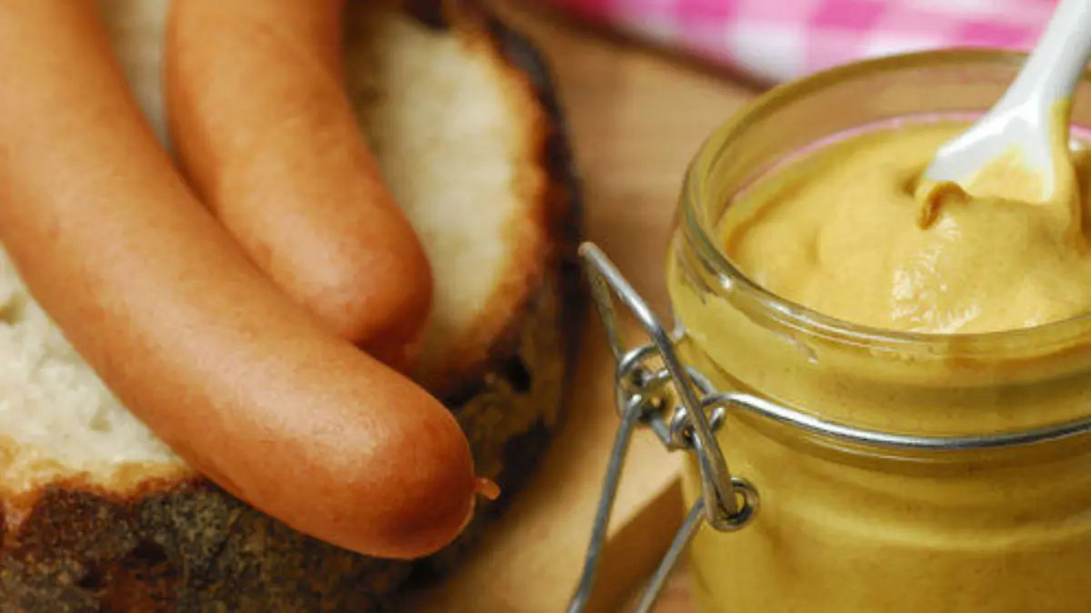 Senfglas, Senf, Wuerstchen auf Brot, Wiener Wuerstchen, Schneidebrett, Gewuerz / Wiener Würstchen