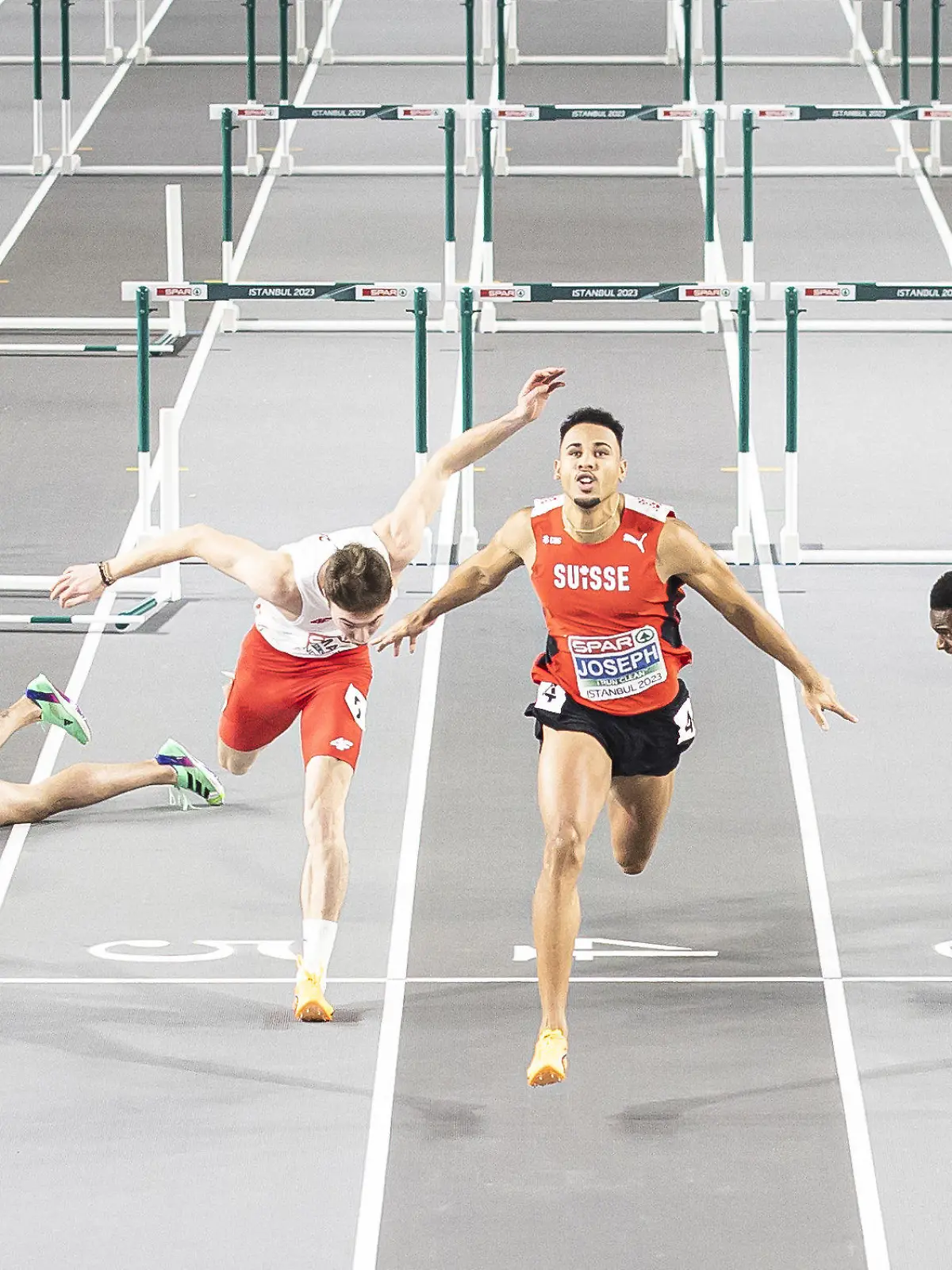 05.03.2023, Türkei, Istanbul: Leichtathletik/Halle: Europameisterschaft, Männer 60 Meter Hürden, Finale: Während Enrique Llopis aus Spanien (l-r) nach einem Sturz am Boden liegt, erreichen Jakub Szymanski aus Polen, Sieger Jason Joseph aus der Schweiz und Just Kwaou-Mathey aus Frankreich das Ziel. (zu dpa "Sorgen um spanischen Hürdensprinter Llopis nach Sturz") Foto: Michael Buholzer/KEYSTONE/dpa +++ dpa-Bildfunk +++