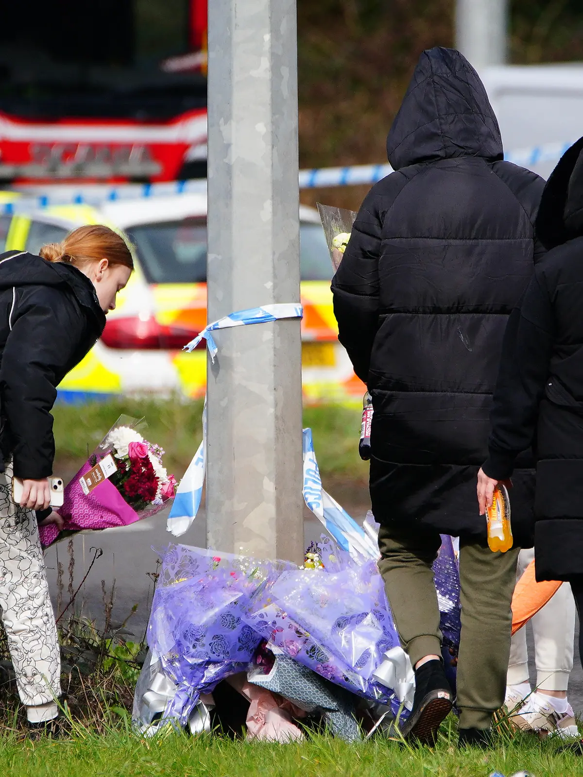 St Mellons deaths. A group of people lay floral tributes left near the scene in the St Mellons area of Cardiff where three people who disappeared on a night out have died in a road traffic accident. Two others who had also been reported missing have been transported to hospital with serious injuries. Sophie Russon, 20, Eve Smith, 21, and Darcy Ross, 21, who had made the trip from Porthcawl, and Rafel Jeanne, 24, and Shane Loughlin, 32, both from Cardiff, had last been seen in the city in the early hours of Saturday. Picture date: Monday March 6, 2023. See PA story POLICE Cardiff. Photo credit should read: Ben Birchall/PA Wire URN:71261775