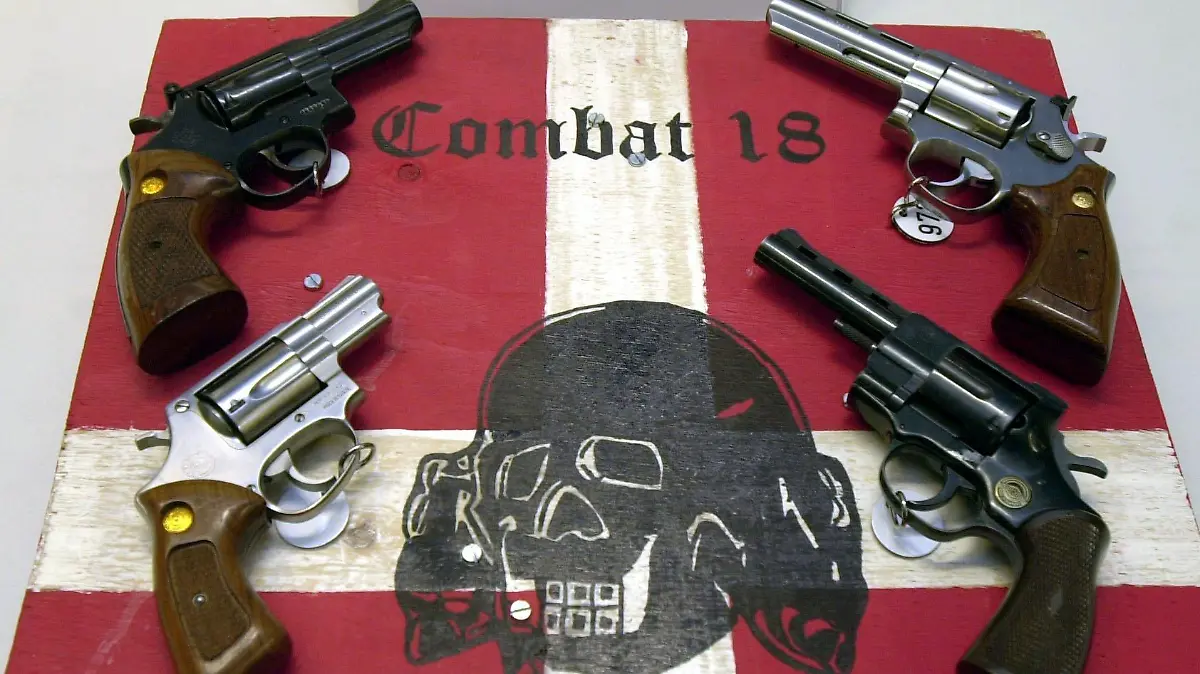 ARCHIV - 27.10.2003, Schleswig-Holstein, Kiel: Sichergestellte Waffen und ein Schild der kriminellen Neonazi-Gruppe «Combat 18» liegen im schleswig-holsteinischen Landeskriminalamt (LKA). Der niedersächsische Innenminister Pistorius (SPD) pocht auf ein Verbot der rechtsextremen Gruppierung «Combat 18». «Wenn wir «Combat 18» verfassungsfest verbieten können, sollten wir das so schnell wie möglich tun», sagte Pistorius der Zeitung taz. Foto: Horst Pfeiffer/dpa +++ dpa-Bildfunk +++