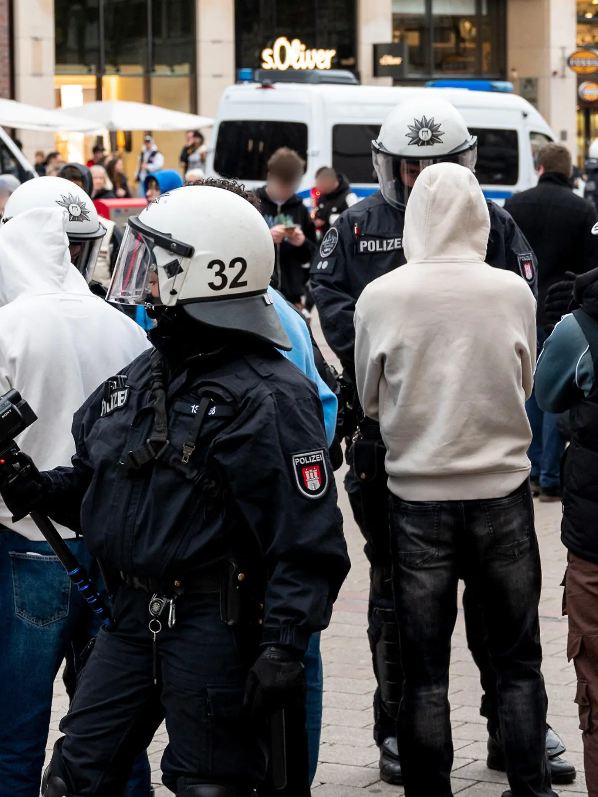 04.03.2023, Hamburg: Polizisten kontrollieren in der Einkaufsstraße Mönkebergstraße mehrere Jugendliche. In der Hamburger Innenstadt ist es am Nachmittag zu einer Auseinandersetzung zwischen Dutzenden Jugendlichen und jungen Erwachsenen sowie der Polizei gekommen. (zu dpa: «Jugendliche und Polizei liefern sich Katz- und Maus-Spiel in Hamburg») Foto: Daniel Bockwoldt/dpa - ACHTUNG: Person(en) wurde(n) aus rechtlichen Gründen gepixelt +++ dpa-Bildfunk +++