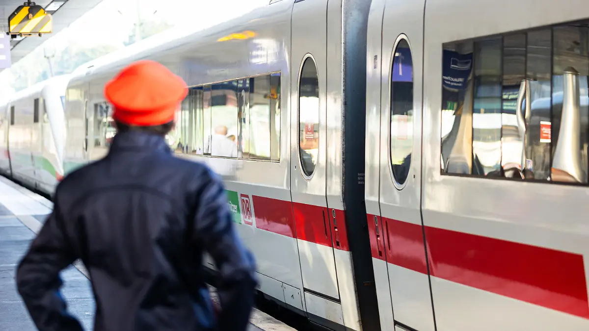 ARCHIV - 02.09.2021, Niedersachsen, Hannover: Ein Mitarbeiter der Deutschen Bahn (DB) steht neben einem ICE-Zug an einem Gleis im Hauptbahnhof Hannover. Bei der Deutschen Bahn sollen Notare herausfinden, welche von zwei konkurrierenden Gewerkschaften in den einzelnen Betrieb mehr Mitglieder hat - die größere Eisenbahn- und Verkehrsgewerkschaft pocht (EVG) nun auf mehr Tempo bei dem Verfahren. (zu dpa «Bahn-Gewerkschaft EVG pocht auf Tempo bei Mitgliederzählung») Foto: Michael Matthey/dpa +++ dpa-Bildfunk +++