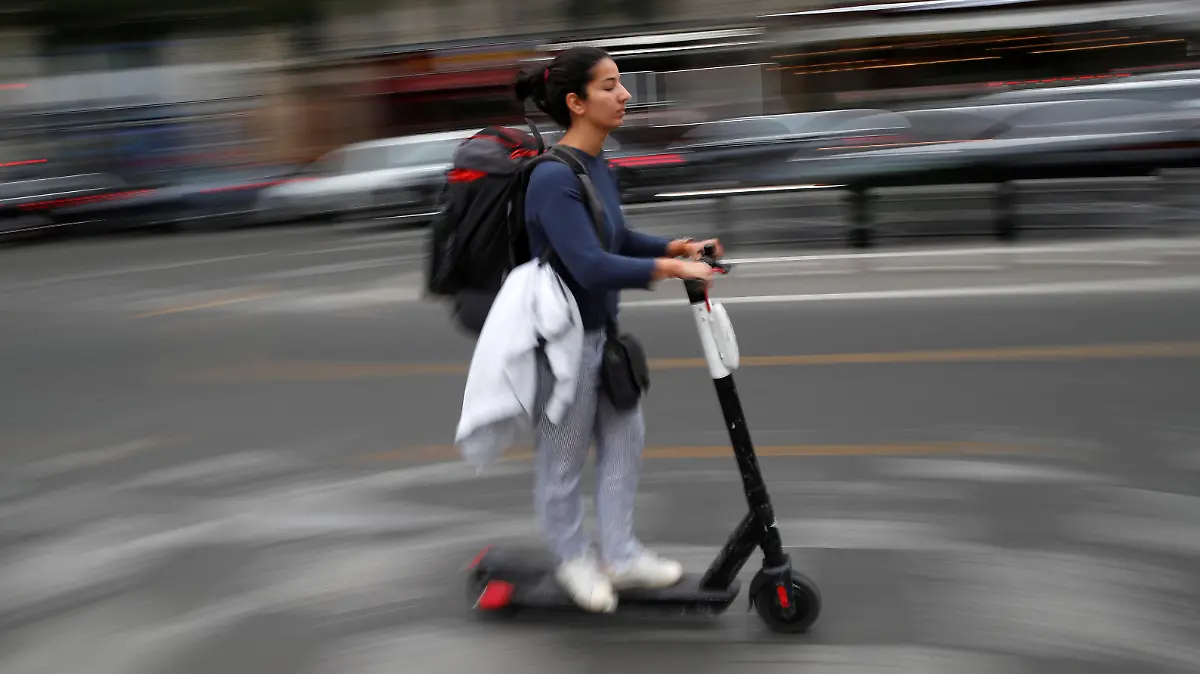 A woman rides a dock-free electric scooter in a street of Paris during a strike by all unions of the Paris transport network (RATP) against pension reform plans in Paris, France, September 13, 2019.  REUTERS/Christian Hartmann