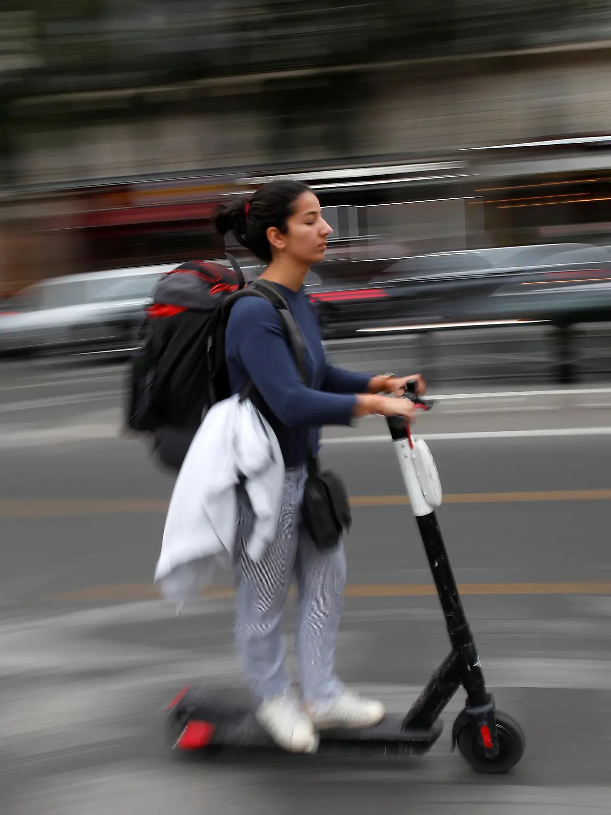 A woman rides a dock-free electric scooter in a street of Paris during a strike by all unions of the Paris transport network (RATP) against pension reform plans in Paris, France, September 13, 2019.  REUTERS/Christian Hartmann