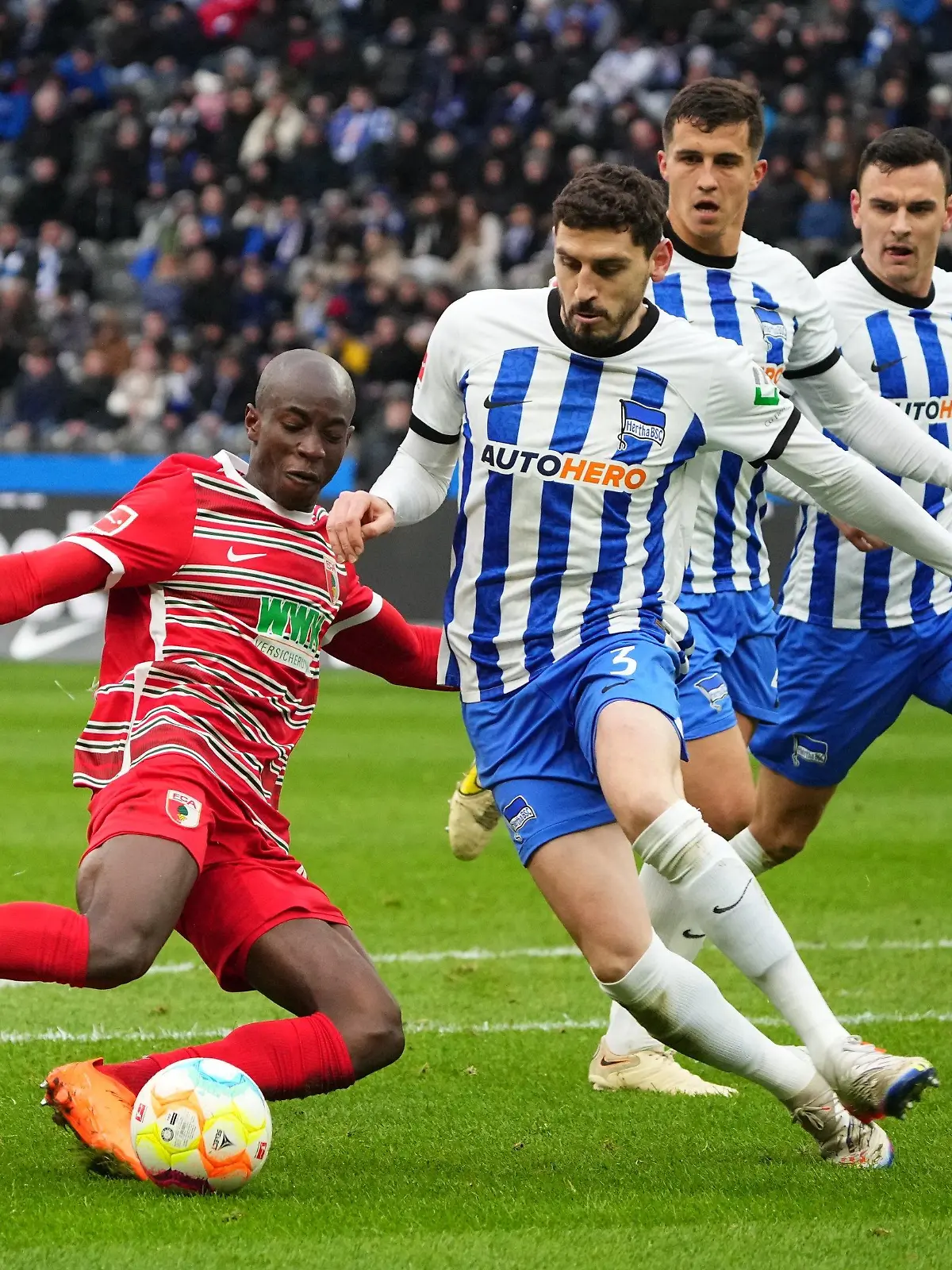 25.02.2023, Berlin: Fußball: Bundesliga, Hertha BSC - FC Augsburg, 22. Spieltag, Olympiastadion, Augsburgs Kelvin Yeboah (l) gegen Herthas Agustin Maximiliano Rogel Paita (M). Foto: Soeren Stache/dpa - WICHTIGER HINWEIS: Gemäß den Vorgaben der DFL Deutsche Fußball Liga bzw. des DFB Deutscher Fußball-Bund ist es untersagt, in dem Stadion und/oder vom Spiel angefertigte Fotoaufnahmen in Form von Sequenzbildern und/oder videoähnlichen Fotostrecken zu verwerten bzw. verwerten zu lassen. +++ dpa-Bildfunk +++
