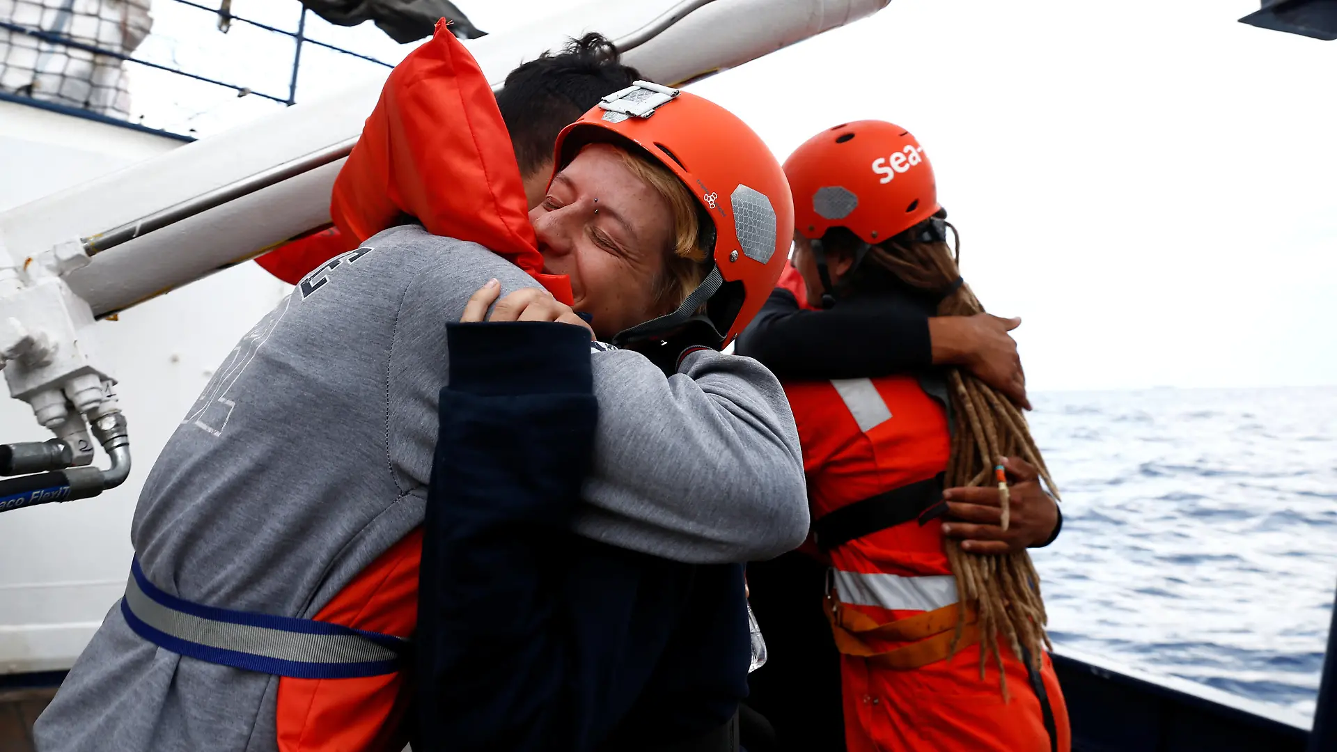 Tunisian migrants embrace crew members on the German NGO Sea-Eye migrant rescue ship 'Alan Kurdi' while waiting to be transferred to Malta, in international waters off Malta in the central Mediterranean Sea, September 10, 2019. REUTERS/Darrin Zammit Lupi