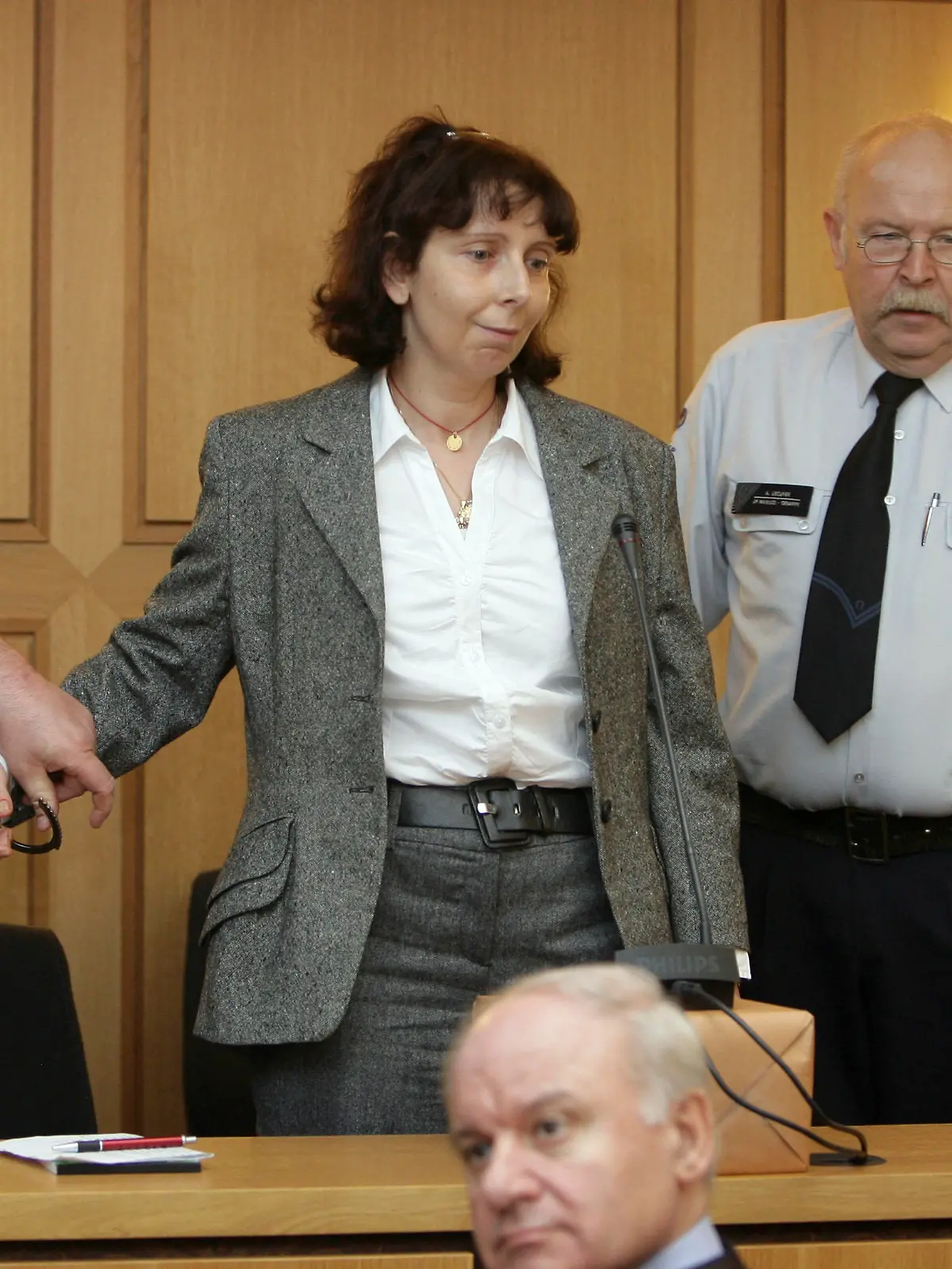 A police officer removes the handcuffs of GeneviÃšve Lhermitte, centre, as she talks with her lawyer Xavier Magnee, botttom right, before the start of her trail where Lhermitte stands accused in the murder of her five children, in Nivelles, Belgium, Monday, Dec. 8, 2008. Mother, Genevieve Lhermitte, stands trial for the killing of her five children on Feb. 28, 2007, before trying to commit suicide at their home in the Belgian city of Nivelles. (AP Photo/Denis Closon, Pool)