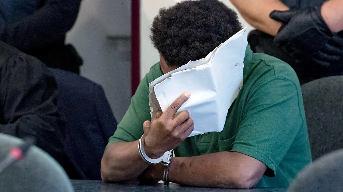 10.09.2019, Sachsen-Anhalt, Dessau-Roßlau: Ein angeklagter 27-jähriger Mann verdeckt im Landgericht Dessau sein Gesicht. Die Staatsanwaltschaft wirft dem derzeit inhaftierten Mann, der aus Niger stammt, schweren sexuellen Missbrauch von Kindern in Tateinheit mit Vergewaltigung und Körperverletzung eines neunjährigen Mädchens vor. Die Tat hat sich im Juni auf den Elbwiesen in Roßlau ereignet. Foto: Hendrik Schmidt/dpa-Zentralbild/dpa +++ dpa-Bildfunk +++