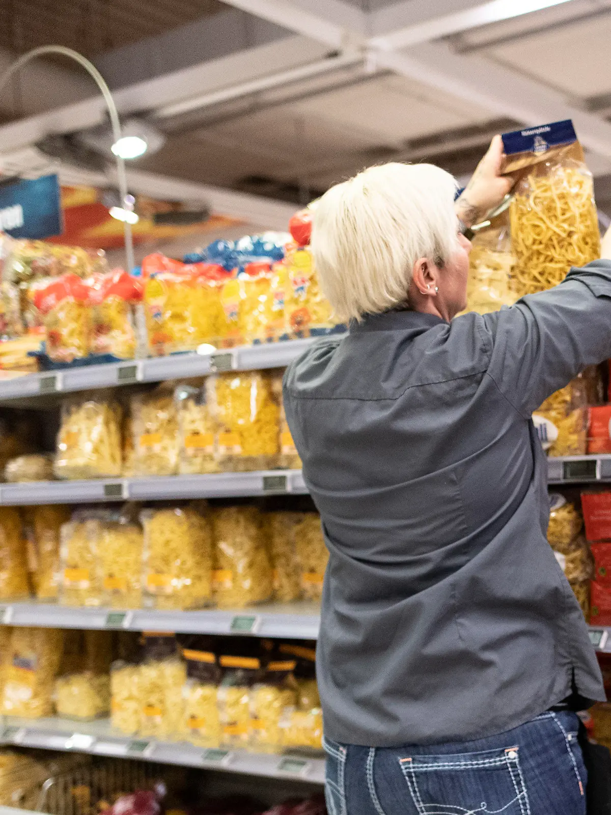 17.03.2020, Baden-Württemberg, Offenburg: Eine Mitarbeiterin von Edeka füllt ein Regal mit Nudeln auf. Laut Edeka ist während der Coronavirus-Lage eine ausreichende Warenversorgung der Märkte aktuell auch weiterhin sichergestellt. Foto: Patrick Seeger/dpa +++ dpa-Bildfunk +++
