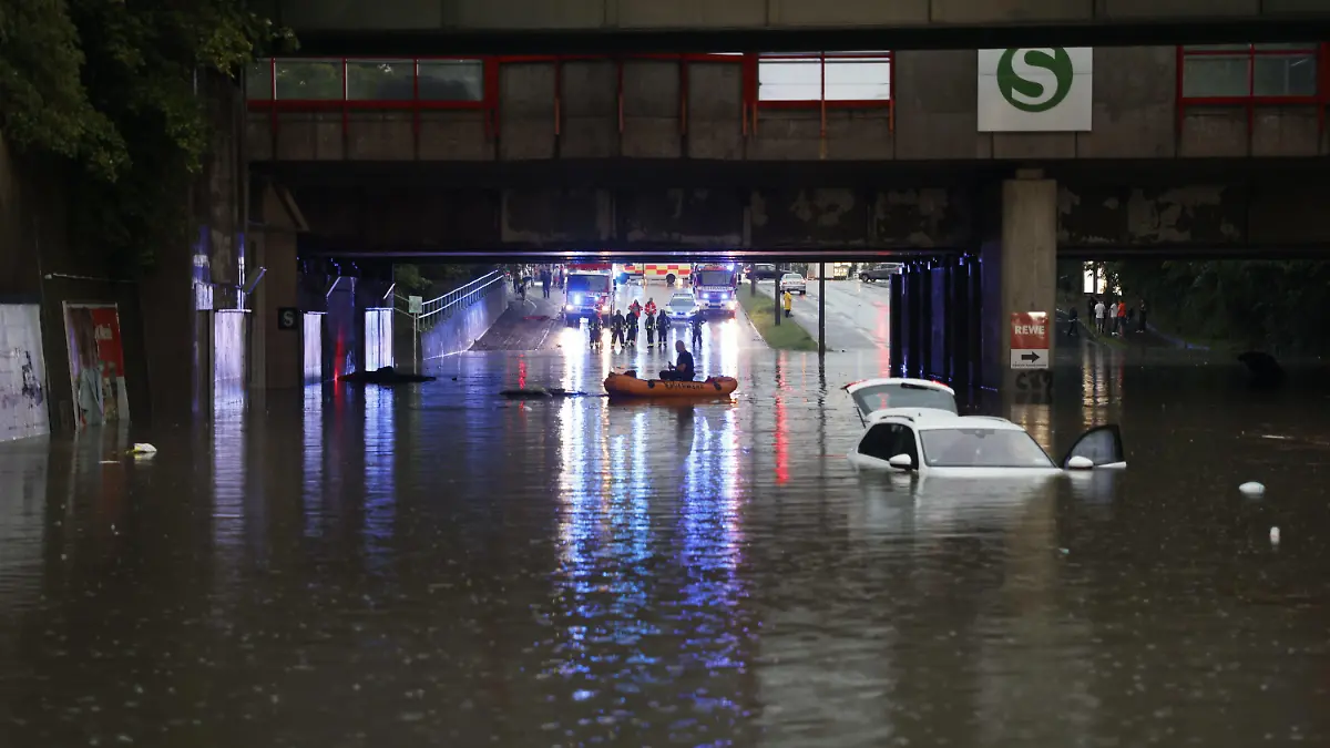 17.08.2023, Bayern, Nürnberg: Einsatzkräfte der Feuerwehr können nur noch mit einem Schlauchboot zu den Autos in einer überschwemmten Unterführung gelangen. Starkregen hat in Nürnberg am Donnerstagabend zu zahlreichen Einsätzen von Polizei und Feuerwehr geführt. Viele Keller und Tiefgaragen seien vollgelaufen, in Unterführungen seien Autos im Wasser stehen geblieben und Insassen eingeschlossen gewesen. Foto: Oßwald/News5 /dpa +++ dpa-Bildfunk +++
