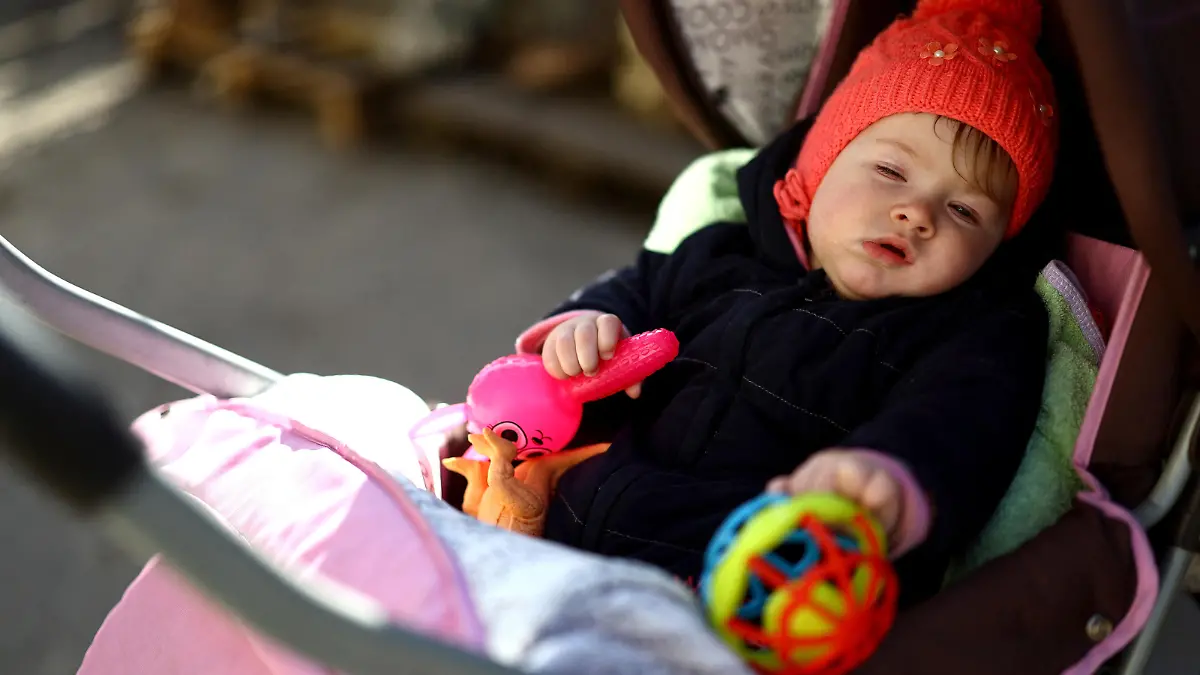 Baby Kateryna, who was born during the Russian occupation, falls asleep in her pram at the family house that is just 1.5 kilometers from the Russian-controlled side of the Dnipro River, where artillery fires daily at Kherson, amid Russia's invasion of Ukraine, in Antonivka, Kherson region, Ukraine, February 21, 2023. REUTERS/Lisi Niesner