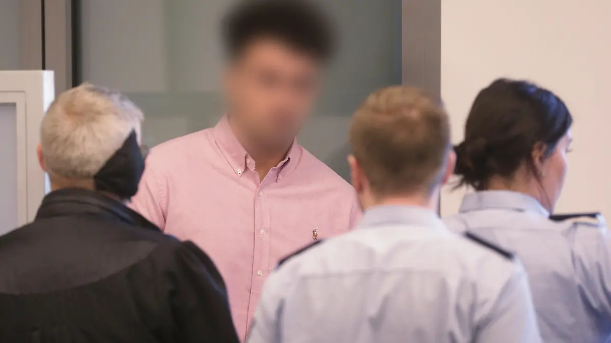 21.08.2019, Nordrhein-Westfalen, Wuppertal: Andreas Trode (l), Rechtsanwalt, unterhält sich mit seinem Mandanten, dem 22-jährigen Angeklagten. Mit der sogenannten «Loverboy»-Masche sollen zwei Männer und ein Jugendlicher junge Frauen in Wuppertal in die Zwangsprostitution getrieben haben. Vor dem Wuppertaler Landgericht müssen sie sich nun verantworten. Die Staatsanwaltschaft wirft ihnen Zuhälterei, gewerbsmäßige Zwangsprostitution, gefährliche Körperverletzung und schweren Raub in mehreren Fällen vor. (Die Angeklagten wurden zum Schutz der Persönlichkeitsrechte unkenntlich gemacht.) Foto: David Young/dpa +++ dpa-Bildfunk +++
