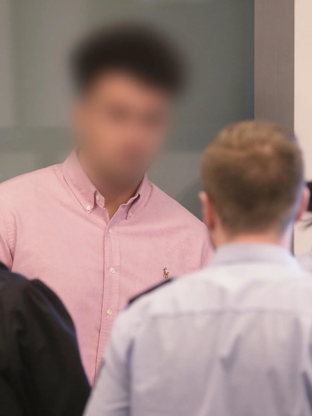 21.08.2019, Nordrhein-Westfalen, Wuppertal: Andreas Trode (l), Rechtsanwalt, unterhält sich mit seinem Mandanten, dem 22-jährigen Angeklagten. Mit der sogenannten «Loverboy»-Masche sollen zwei Männer und ein Jugendlicher junge Frauen in Wuppertal in die Zwangsprostitution getrieben haben. Vor dem Wuppertaler Landgericht müssen sie sich nun verantworten. Die Staatsanwaltschaft wirft ihnen Zuhälterei, gewerbsmäßige Zwangsprostitution, gefährliche Körperverletzung und schweren Raub in mehreren Fällen vor. (Die Angeklagten wurden zum Schutz der Persönlichkeitsrechte unkenntlich gemacht.) Foto: David Young/dpa +++ dpa-Bildfunk +++