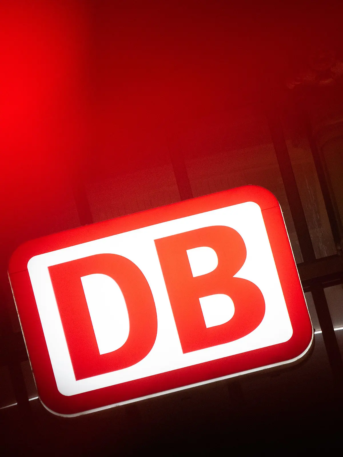 28.02.2023, Hessen, Frankfurt/Main: Das Logo der Deutschen Bahn leuchtet am Hauptbahnhof hinter einer Ampel. In Fulda findet am 28. Februar der Auftakt der Tarifverhandlungen zwischen der Gewerkschaft EVG und der Deutsche Bahn AG sowie weiteren rund 50 Bahnunternehmen statt. Foto: Sebastian Gollnow/dpa +++ dpa-Bildfunk +++