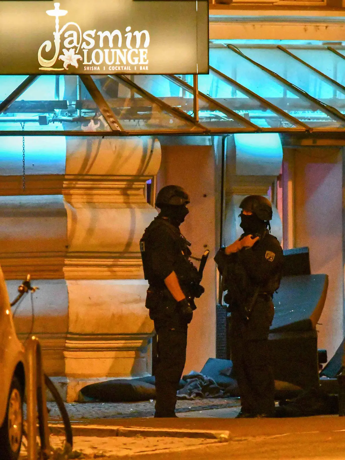 20.08.2019, Sachsen-Anhalt, Magdeburg: Polizisten in Schutzausrüstung stehen vor einem Lokal, vor dem umgestürzte Möbel stehen. Bei einer gewaltsamen Auseinandersetzung im Zentrum sind in der Nacht mindestens zwei Menschen verletzt worden. Wie die Polizei mitteilte, bewarf eine Gruppe gegen Mitternacht zunächst einige Gäste einer Shisha-Bar mit Möbeln. Bei der anschließenden Auseinandersetzung setzten beide Seiten auch Schusswaffen ein. Foto: Tom Wunderlich/dpa-Zentralbild/dpa +++ dpa-Bildfunk +++