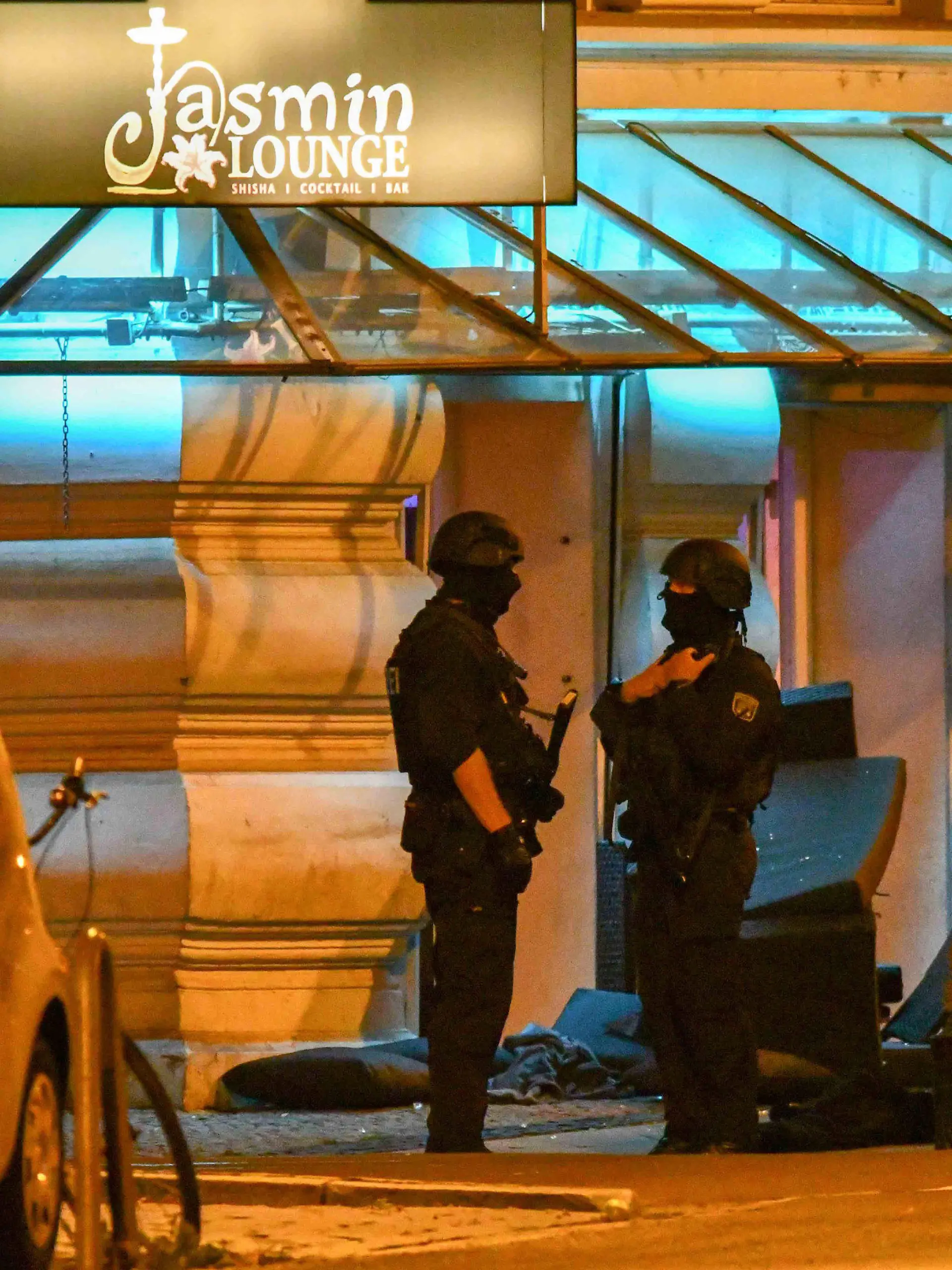 20.08.2019, Sachsen-Anhalt, Magdeburg: Polizisten in Schutzausrüstung stehen vor einem Lokal, vor dem umgestürzte Möbel stehen. Bei einer gewaltsamen Auseinandersetzung im Zentrum sind in der Nacht mindestens zwei Menschen verletzt worden. Wie die Polizei mitteilte, bewarf eine Gruppe gegen Mitternacht zunächst einige Gäste einer Shisha-Bar mit Möbeln. Bei der anschließenden Auseinandersetzung setzten beide Seiten auch Schusswaffen ein. Foto: Tom Wunderlich/dpa-Zentralbild/dpa +++ dpa-Bildfunk +++