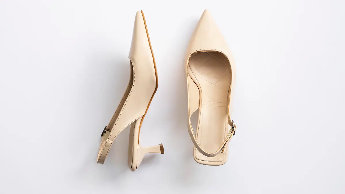 Beige short heels isolated on white background. Fashion concept, catwalk. A modern and trendy shoe store. Top view.