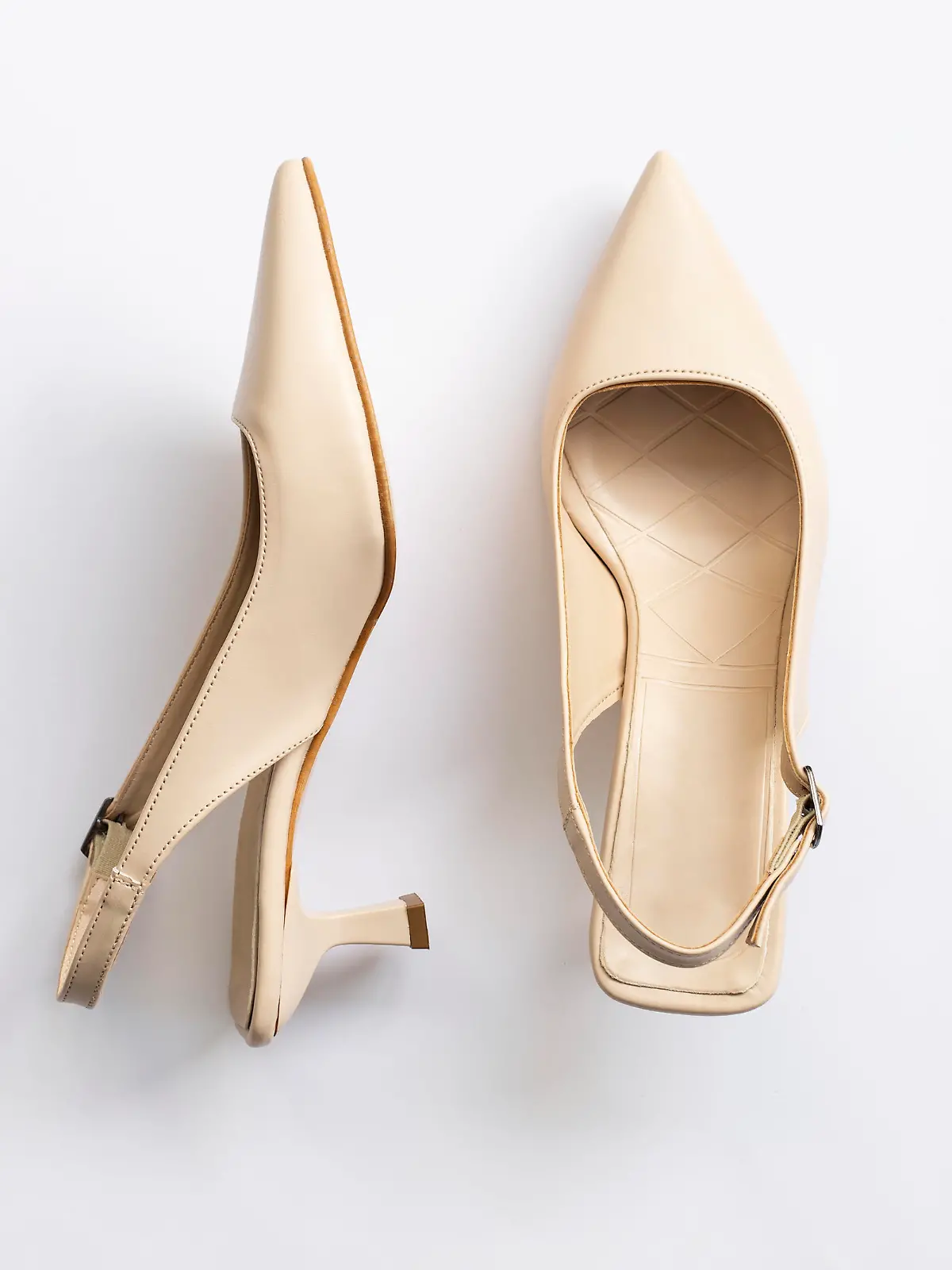 Beige short heels isolated on white background. Fashion concept, catwalk. A modern and trendy shoe store. Top view.
