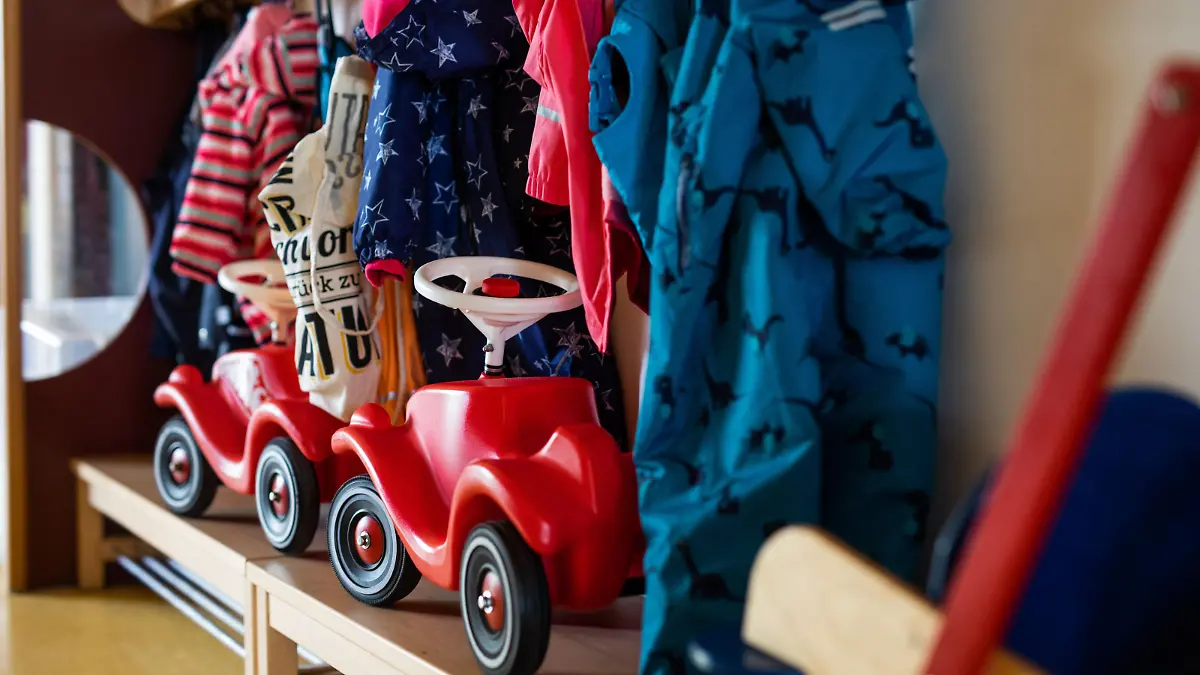 Bobbycars stehen in einer Garderobe auf Bänken unter Jacken von Kindern einer Kindertagesstätte. Eltern, die an ihrer Arbeitsstelle «unabkömmlich» sind, können ihre Kinder notbetreuen lassen - ohne Nachweispflicht. Die Hürden sind also gering und Schulen und Kitas werden trotz Lockdowns immer voller. Das sorgt auch für Kritik.