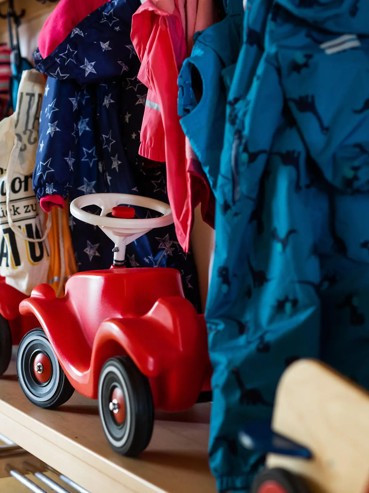 Bobbycars stehen in einer Garderobe auf Bänken unter Jacken von Kindern einer Kindertagesstätte. Eltern, die an ihrer Arbeitsstelle «unabkömmlich» sind, können ihre Kinder notbetreuen lassen - ohne Nachweispflicht. Die Hürden sind also gering und Schulen und Kitas werden trotz Lockdowns immer voller. Das sorgt auch für Kritik.