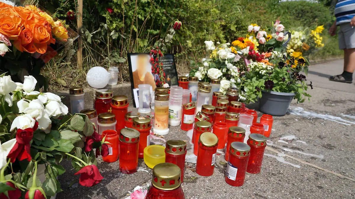 05.08.2019, Baden-Württemberg, Stuttgart: Kerzen und Blumen stehen am Tatort um ein Porträt des dort getöteten Mannes herum. Die Bestürzung ist auch Tage nach dem Schwert-Angriff in Stuttgart weiterhin groß. Der inzwischen in Untersuchungshaft sitzende mutmaßliche Täter hatte nach Angaben der Staatsanwaltschaft ausschließlich persönliche Beweggründe. Foto: Andreas Rosar/dpa - ACHTUNG: Die Person auf dem Porträt wurde aus rechtlichen Gründen gepixelt +++ dpa-Bildfunk +++