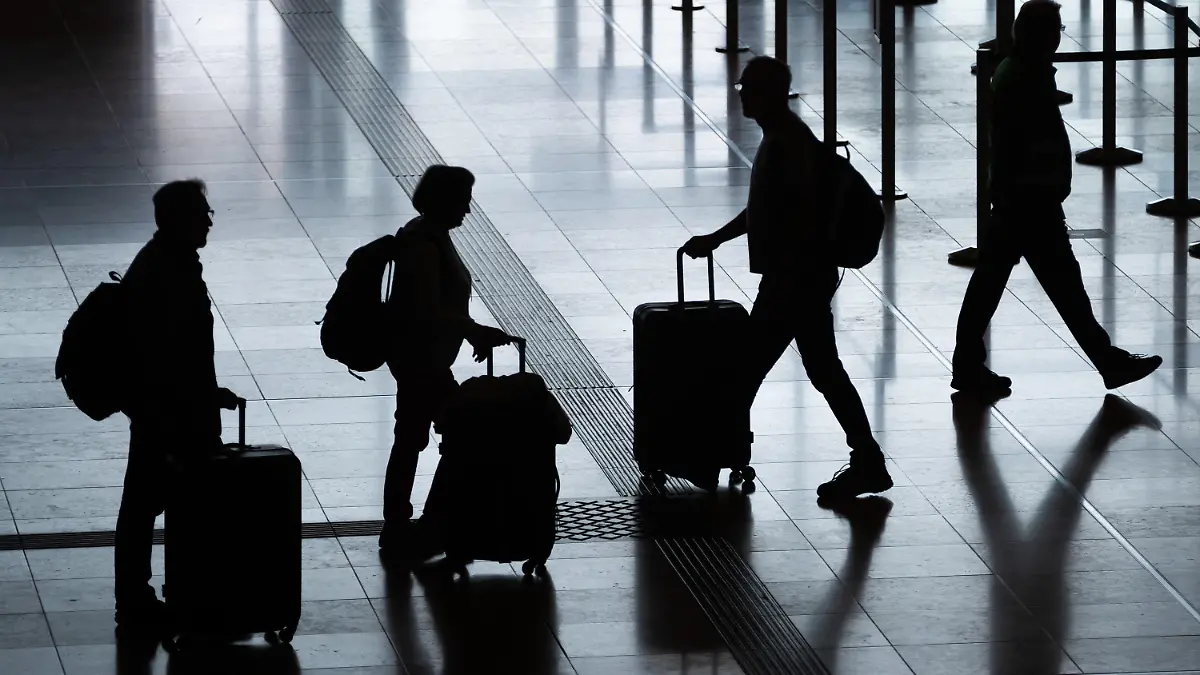 ARCHIV - 03.06.2022, Berlin: Fluggäste gehen mit Rollkoffern am Flughafen Berlin Brandenburg (BER) «Willy Brandt» durch das Terminal 1. In diesem Jahr wird etwa jeder vierte Deutsche beim Urlaub sparen. Das geht aus einer Umfrage des Automobilclubs ADAC unter 5000 Personen hervor. (zu dpa: «Umfrage: Jeder vierte Deutsche wird beim Urlaub sparen») Foto: Christoph Soeder/dpa +++ dpa-Bildfunk +++