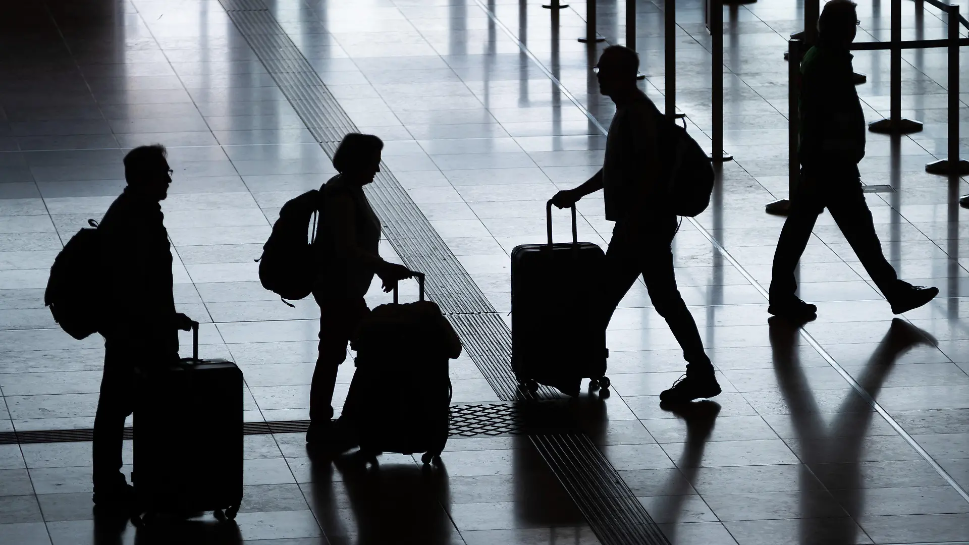 ARCHIV - 03.06.2022, Berlin: Fluggäste gehen mit Rollkoffern am Flughafen Berlin Brandenburg (BER) «Willy Brandt» durch das Terminal 1. In diesem Jahr wird etwa jeder vierte Deutsche beim Urlaub sparen. Das geht aus einer Umfrage des Automobilclubs ADAC unter 5000 Personen hervor. (zu dpa: «Umfrage: Jeder vierte Deutsche wird beim Urlaub sparen») Foto: Christoph Soeder/dpa +++ dpa-Bildfunk +++