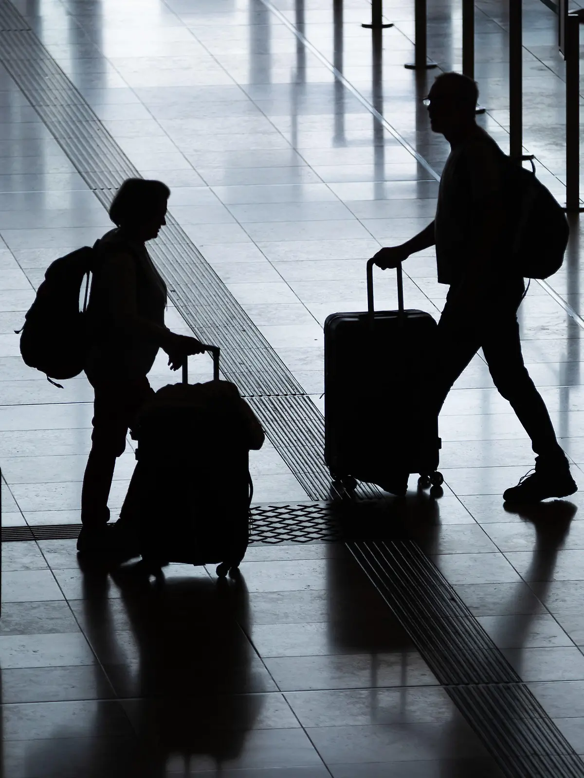 ARCHIV - 03.06.2022, Berlin: Fluggäste gehen mit Rollkoffern am Flughafen Berlin Brandenburg (BER) «Willy Brandt» durch das Terminal 1. In diesem Jahr wird etwa jeder vierte Deutsche beim Urlaub sparen. Das geht aus einer Umfrage des Automobilclubs ADAC unter 5000 Personen hervor. (zu dpa: «Umfrage: Jeder vierte Deutsche wird beim Urlaub sparen») Foto: Christoph Soeder/dpa +++ dpa-Bildfunk +++