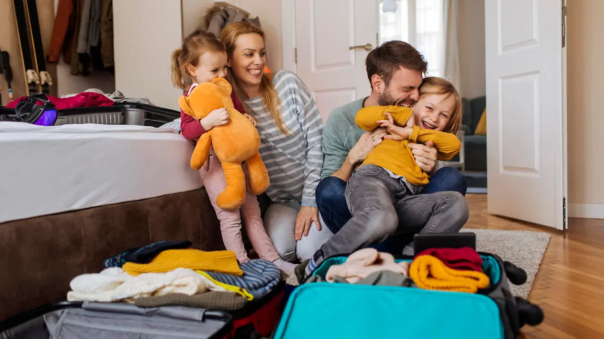 Happy family having fun while packing their bags for a winter vacation