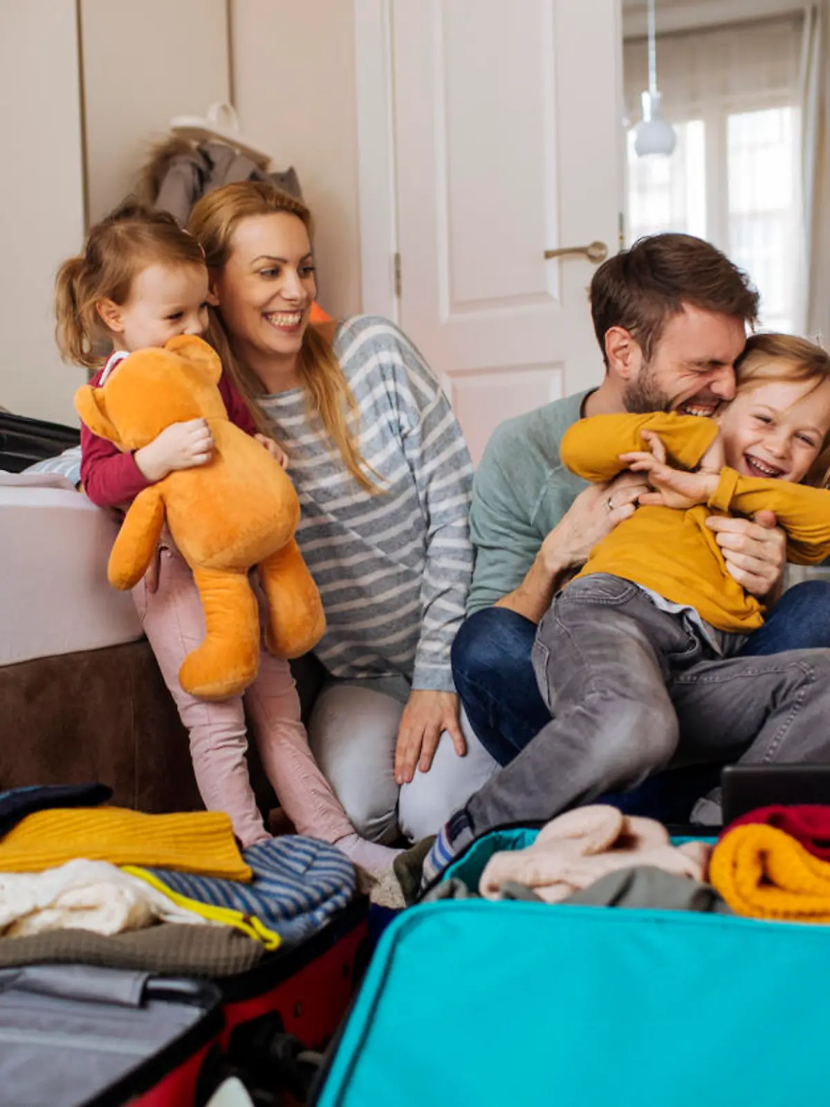 Happy family having fun while packing their bags for a winter vacation