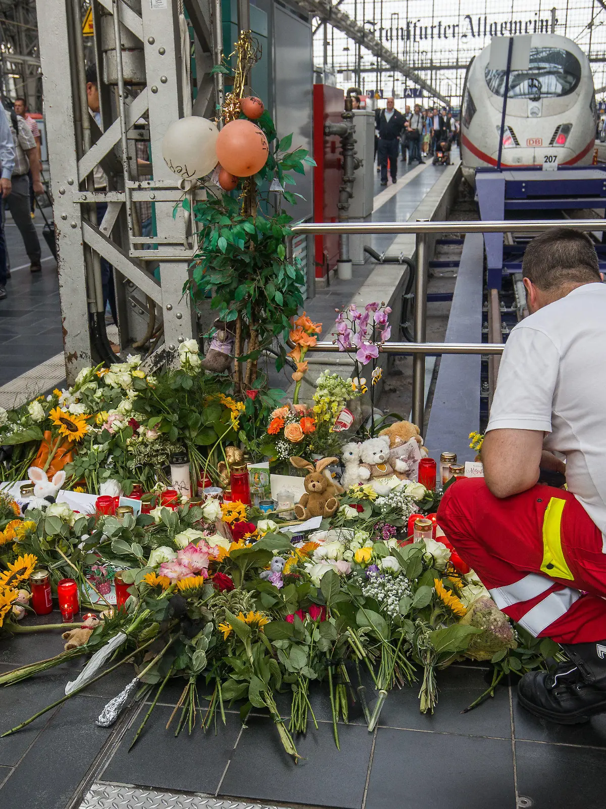 dpatopbilder - 30.07.2019, Hessen, Frankfurt/Main: Ein Ersthelfer, der am Tag zuvor vor Ort war, legt am Bahnsteig 7 im Frankfurter Hauptbahnhof Blumen nieder. Ein achtjähriger Junge ist im Frankfurter Hauptbahnhof von einem Mann vor den einfahrenden ICE gestoßen und getötet worden. Foto: Frank Rumpenhorst/dpa +++ dpa-Bildfunk +++