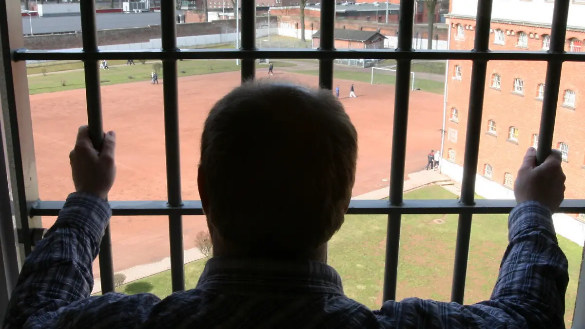 ARCHIV - Ein Mann schaut am 07.03.2006 aus einer Zelle der Strafanstalt Hamburg-Fuhlsbüttel. Erst Niedersachsen, jetzt Hamburg: Nach großem
öffentlichen Druck ist ein entlassener Sexualstraftäter aus der Kurstadt Bad Pyrmont in die Hansestadt gezogen. Seit gut einer Woche
lebt der 53-Jährige nun in Hamburg - und zwingt die
Sicherheitsbehörden zu hohem Aufwand. Sie prüfen, wie gefährlich der Mann noch ist und welche Auflagen er erfüllen sollte. Bis dahin muss die Polizei ihn rund um die Uhr bewachen. Foto: Maurizio Gambarini dpa/lno  +++(c) dpa - Bildfunk+++