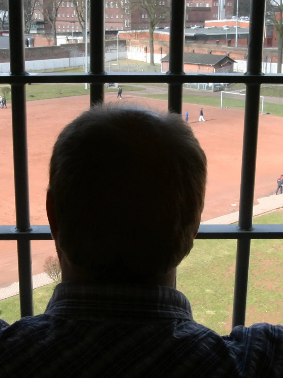 ARCHIV - Ein Mann schaut am 07.03.2006 aus einer Zelle der Strafanstalt Hamburg-Fuhlsbüttel. Erst Niedersachsen, jetzt Hamburg: Nach großem
öffentlichen Druck ist ein entlassener Sexualstraftäter aus der Kurstadt Bad Pyrmont in die Hansestadt gezogen. Seit gut einer Woche
lebt der 53-Jährige nun in Hamburg - und zwingt die
Sicherheitsbehörden zu hohem Aufwand. Sie prüfen, wie gefährlich der Mann noch ist und welche Auflagen er erfüllen sollte. Bis dahin muss die Polizei ihn rund um die Uhr bewachen. Foto: Maurizio Gambarini dpa/lno  +++(c) dpa - Bildfunk+++