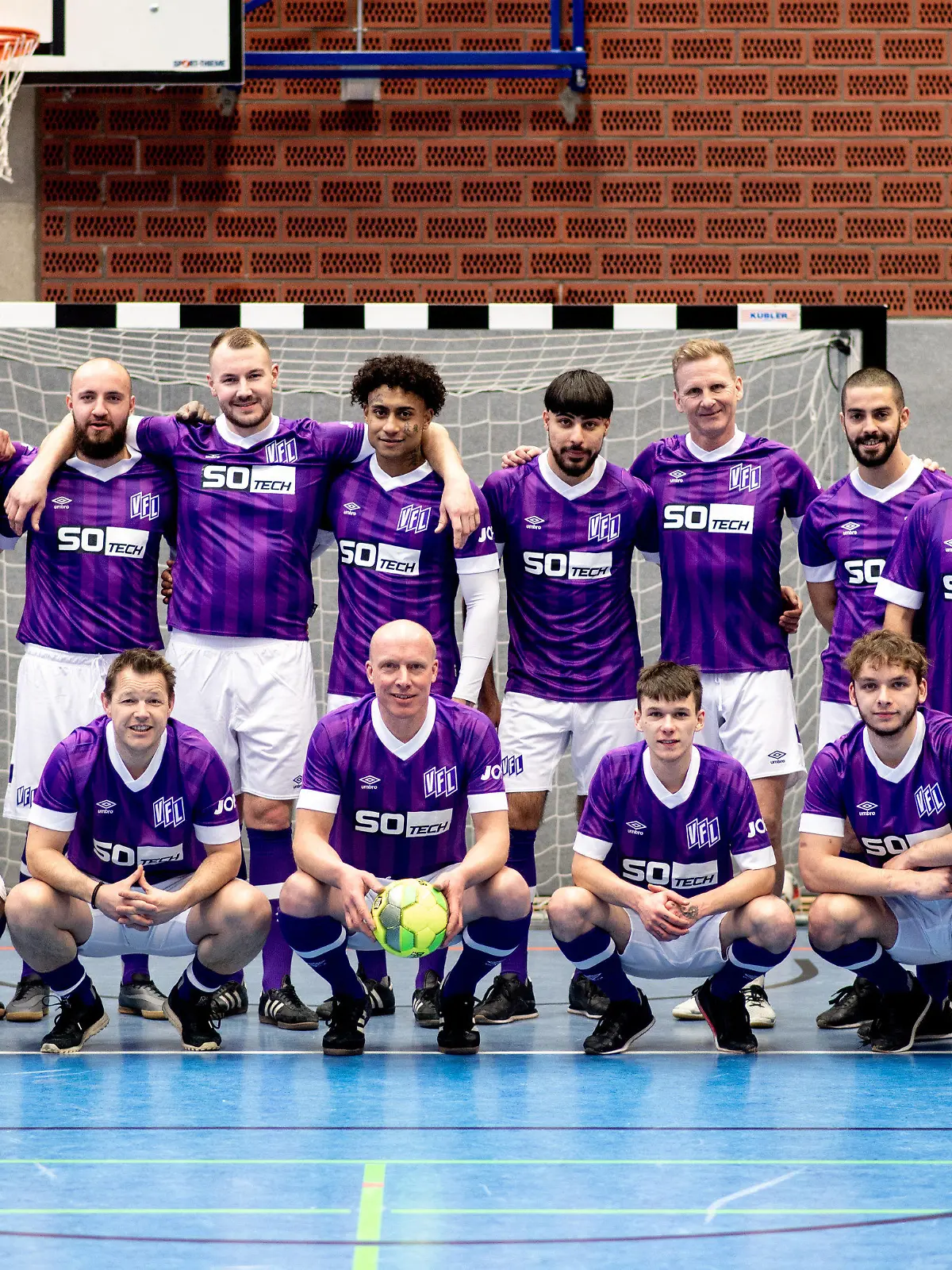 28.02.2023, Niedersachsen, Vechta: Die Fußballmannschaft der Justizvollzugsanstalt für Jungtäter in Vechta steht gemeinsam mit den ehemaligen Fußballprofis vor einem Training im Innenhof. Die Justizvollzugsanstalt Vechta und der VfL Osnabrück haben ihre Kooperation bei der Initiative ·Anstoß für ein neues Leben· vorgestellt. Bei dem Projekt der Sepp-Herberger-Stiftung des Deutschen Fußball-Bundes (DFB) geht es um die Resozialisierung junger Strafgefangener. Foto: Hauke-Christian Dittrich/dpa - ACHTUNG: Nur zur redaktionellen Verwendung im Zusammenhang mit der aktuellen Berichterstattung. +++ dpa-Bildfunk +++