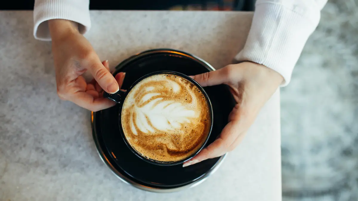 Woman drinking latte at cafe