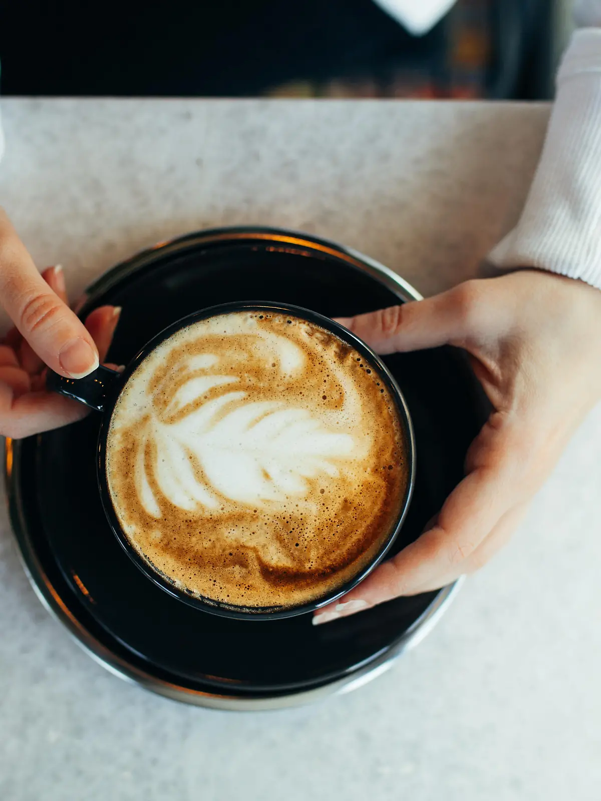 Woman drinking latte at cafe