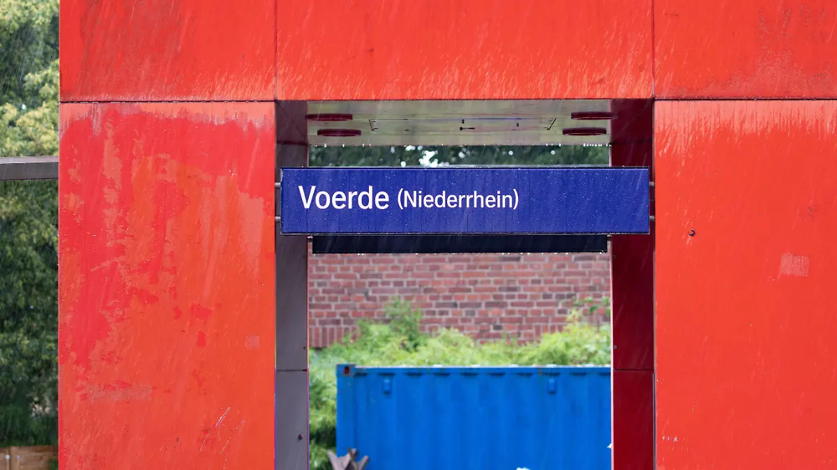 20.07.2019, Nordrhein-Westfalen, Voerde: Die Stationstafel des Bahnhofs in Voerde. Ein 28-jähriger Mann hat nach Polizeiangaben am Bahnhof im niederrheinischen Voerde eine 34-jährige Frau vom Bahnsteig vor einen einfahrenden Zug gestoßen. Die Frau aus Voerde sei am Samstagmorgen ins Gleisbett gestürzt und von dem Regionalexpress überrollt worden, berichtete ein Sprecher der Duisburger Polizei. Trotz der Rettungsbemühungen sei sie noch am Ort gestorben. Foto: Christoph Reichwein/dpa +++ dpa-Bildfunk +++