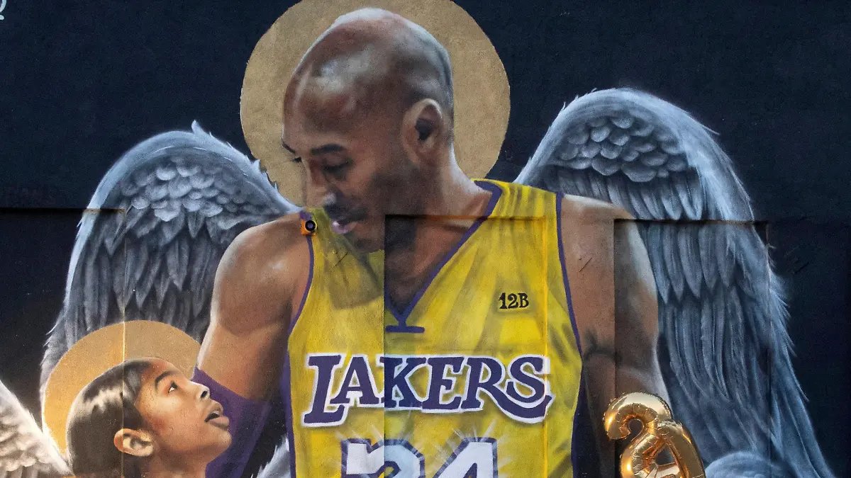 FILE PHOTO: FILE PHOTO: A fan poses by a mural of late Kobe Bryant, who perished one year ago alongside his daughter and seven others when their helicopter crashed into a hillside, in Los Angeles, California, U.S., January 26, 2021. REUTERS/Mario Anzuoni/File Photo/File Photo