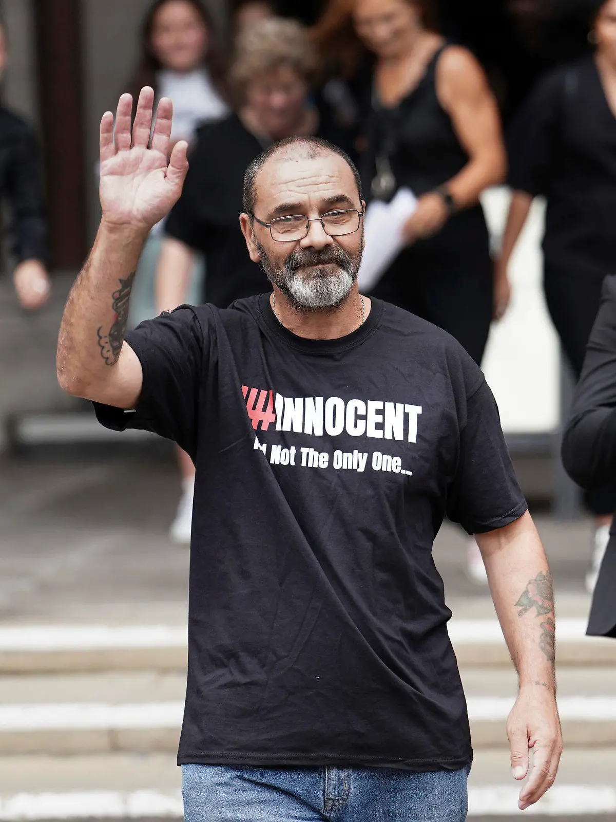 Andrew Malkinson waves as he leave the the Royal Courts of Justice in London, Britain, Wednesday, July 26, 2023. A British man who served nearly 17 years for rape has had his conviction quashed by the country’s Court of Appeal after recently-obtained DNA evidence linked another potential suspect to the crime. Andrew Malkinson, 57, was found guilty of the brutal 2003 attack on a woman in Greater Manchester and jailed for life the following year, with a minimum term of seven years. (Jordan Pettitt/PA via AP)