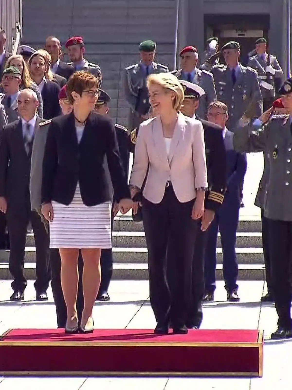 Annegret Kramp-Karrenbauer und Ursula von der Leyen halten Händchen - bei militärischen Ehren in Berlin.