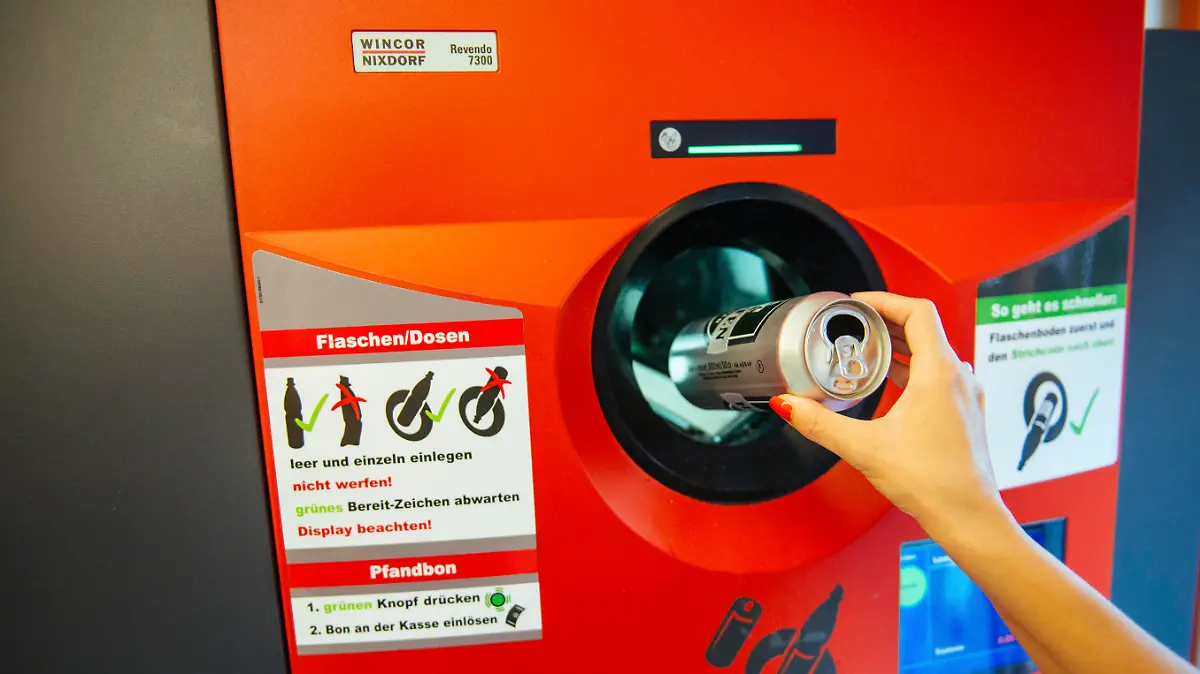 Berlin, Germany - August 31, 2015: Unrecognizable woman throwing empty beer can in recycling machine in order to receive deposit given while paying at the till. In Germany prices are formed on the principle that customar adds 0.08€ when buying drink in glass bottle, while 0.25€ should be added on the beverage price if it is packed in can or plastic bottle. By recycling later on, you receive coupon with that amount which is cashable at the till in any store.