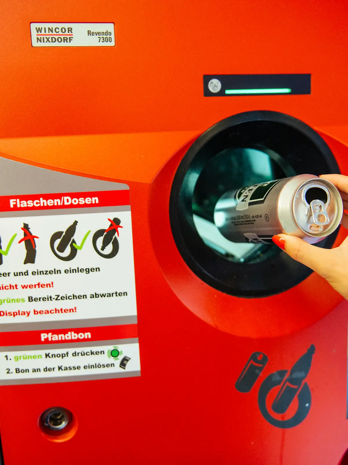 Berlin, Germany - August 31, 2015: Unrecognizable woman throwing empty beer can in recycling machine in order to receive deposit given while paying at the till. In Germany prices are formed on the principle that customar adds 0.08€ when buying drink in glass bottle, while 0.25€ should be added on the beverage price if it is packed in can or plastic bottle. By recycling later on, you receive coupon with that amount which is cashable at the till in any store.