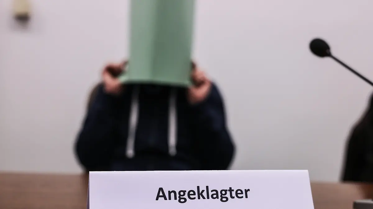 ARCHIV - 06.12.2022, Nordrhein-Westfalen, Köln: Der Angeklagte im Missbrauchskomplex Wermelskirchen hält sich im Gerichtssaal eine Mappe vor das Gesicht. Der Mann soll sich im Internet als Babysitter angeboten und so Kontakt zu den Familien der Opfer bekommen haben. Insgesamt ist er wegen 124 Taten angeklagt, darunter auch wegen Besitz von Kinderpornografie und Beihilfe zum Missbrauch. (zu dpa: «Urteil im Missbrauchskomplex Wermelskirchen erwartet») Foto: Oliver Berg/dpa +++ dpa-Bildfunk +++