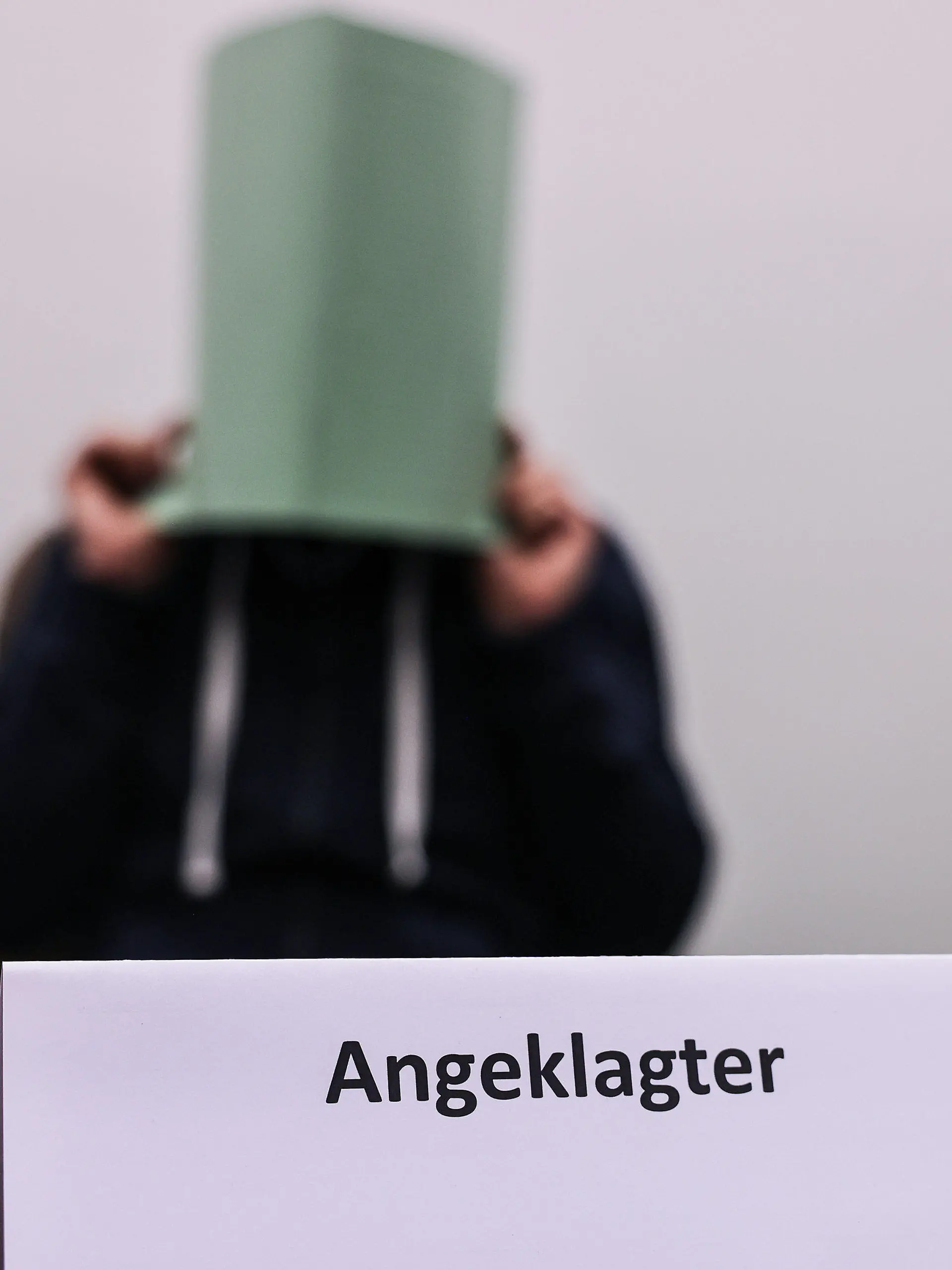 ARCHIV - 06.12.2022, Nordrhein-Westfalen, Köln: Der Angeklagte im Missbrauchskomplex Wermelskirchen hält sich im Gerichtssaal eine Mappe vor das Gesicht. Der Mann soll sich im Internet als Babysitter angeboten und so Kontakt zu den Familien der Opfer bekommen haben. Insgesamt ist er wegen 124 Taten angeklagt, darunter auch wegen Besitz von Kinderpornografie und Beihilfe zum Missbrauch. (zu dpa: «Urteil im Missbrauchskomplex Wermelskirchen erwartet») Foto: Oliver Berg/dpa +++ dpa-Bildfunk +++