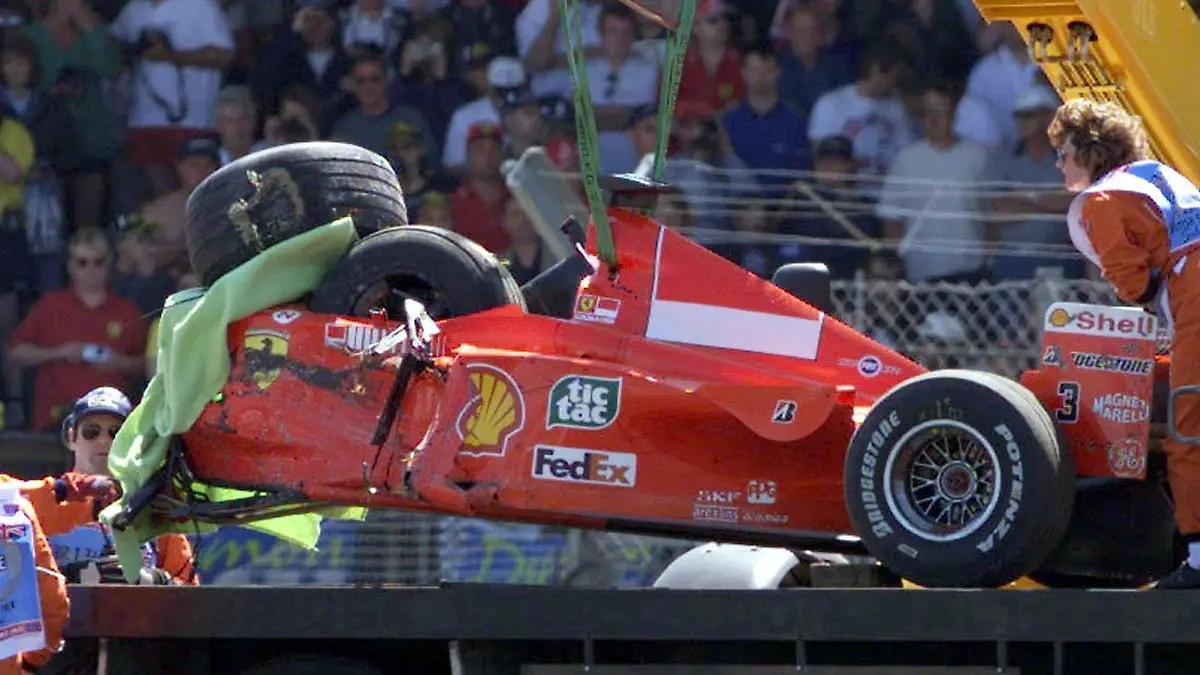 ARCHIV - 10.07.1999, Silverstone: Der zerstörte Formel-1-Rennwagen des Ferrari-Piloten Michael Schumacher wird nach seinem schweren Unfall in der Stowe-Kurve unmittelbar nach dem Start zum 50. Großen Preis von England auf einen Abschleppwagen gehoben. Nur einen wirklich schweren Unfall erlebt Michael Schumacher in seiner Formel-1-Karriere. In Silverstone rast der Ferrari-Star 1999 frontal in einen Reifenstapel und bricht sich das Bein. Der Crash, der ihn lange beschäftigte, passierte am Donnerstag vor 20 Jahren. Foto: Frm/dpa +++ dpa-Bildfunk +++