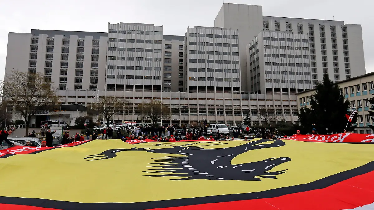 epa04006912 On the day of Michael Schumacher's 45th birthday, Ferrari fans wave a giant flag in a vigil for retired Formula One German racing driver Michael Schumacher outside the 'Centre Hospitalier Universitaire' (CHU) hospital in Grenoble, France, 03 January 2014. Retired Formula One German racing driver Michael Schumacher is still treated at the Grenoble's hospital after he was admitted in a coma with a cranial trauma following a ski accident in Meribel. EPA/GUILLAUME HORCAJUELO +++(c) dpa - Bildfunk+++